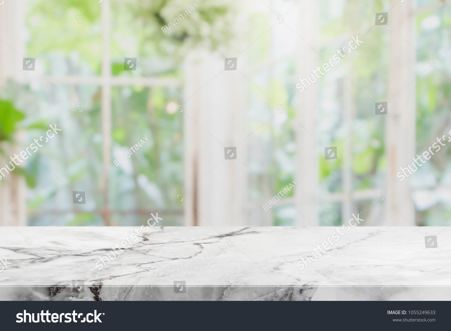 Empty white stone marble table top and blurred of interior room with window view green from tree garden background background - can used for display or montage your products. #1055249633