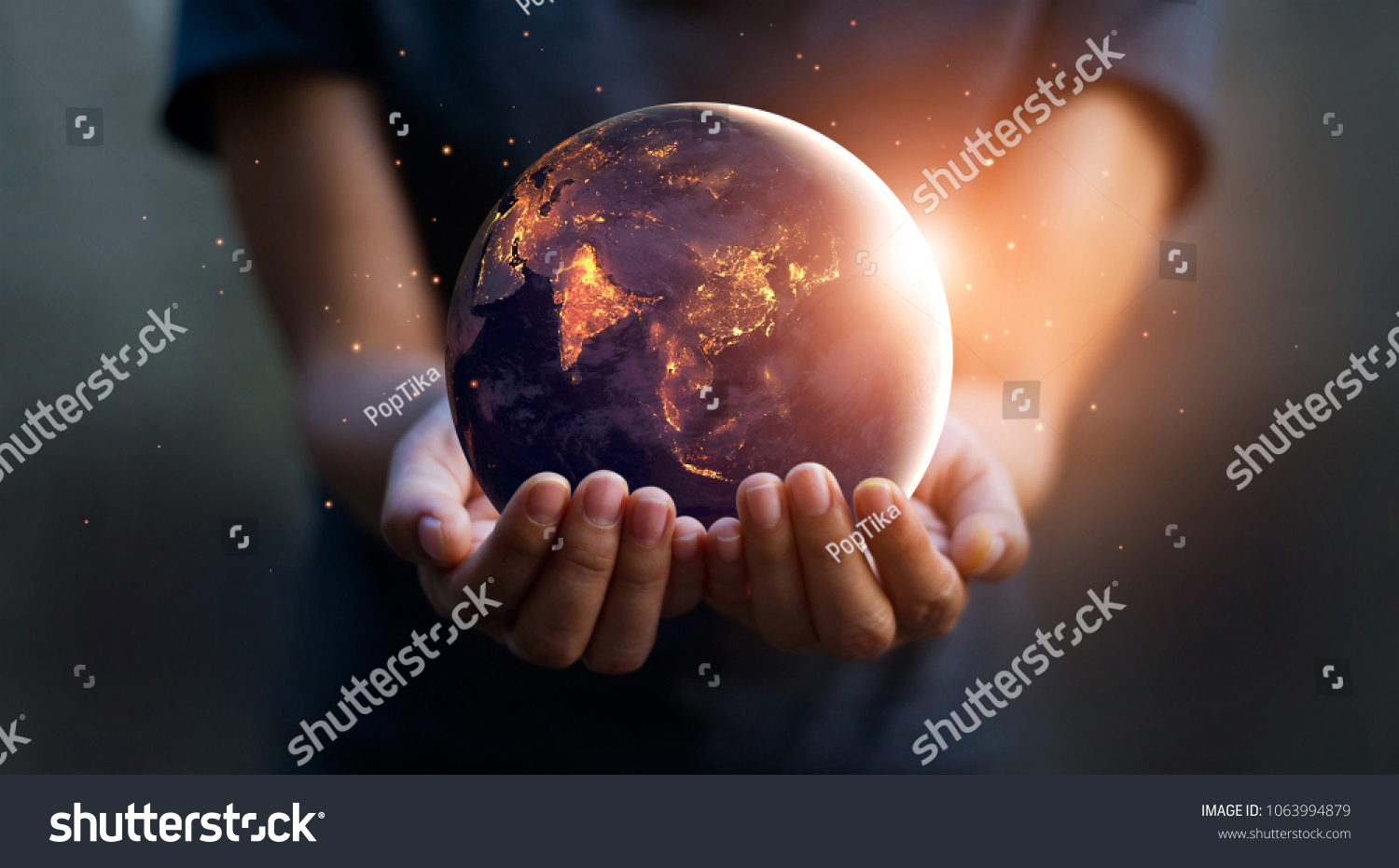 Earth at night was holding in human hands. Earth day. Energy saving concept, Elements of this image furnished by NASA #1063994879
