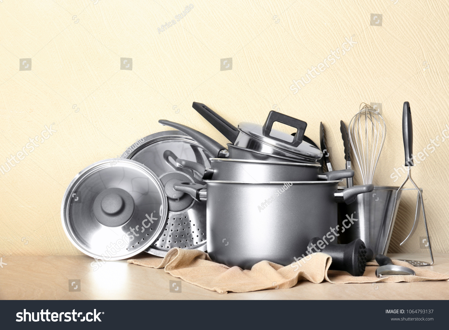 Kitchenware prepared for cooking classes on table against light wall #1064793137