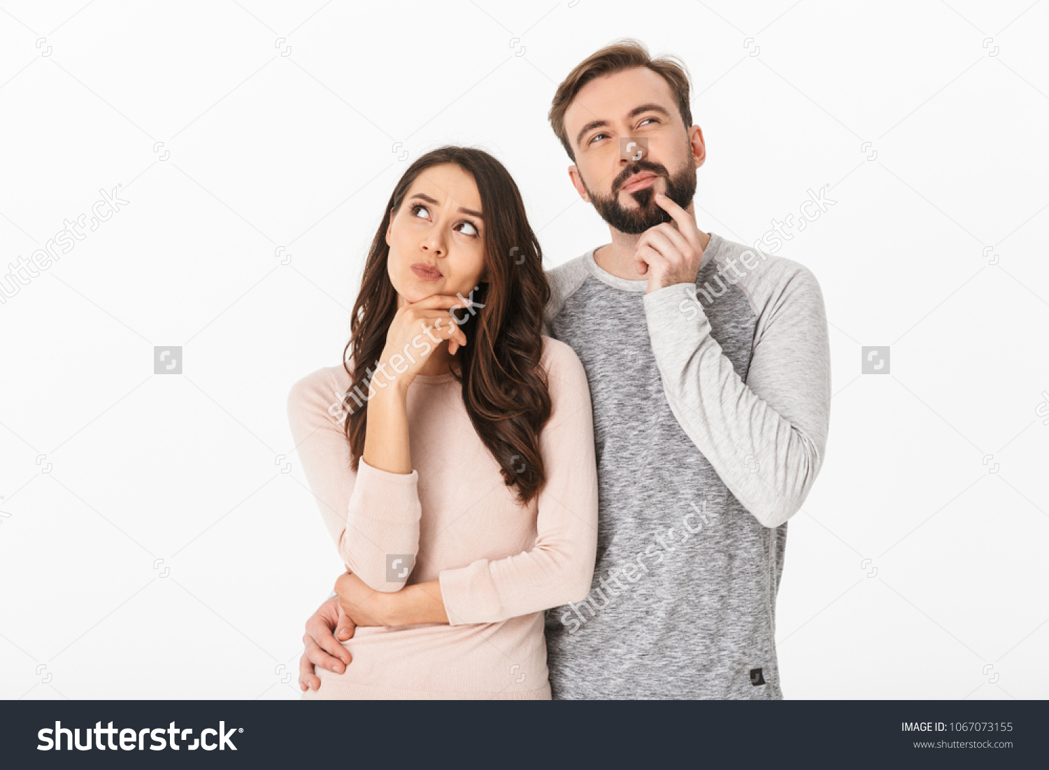 Image of serious thinking young loving couple isolated over white wall background looking aside. #1067073155