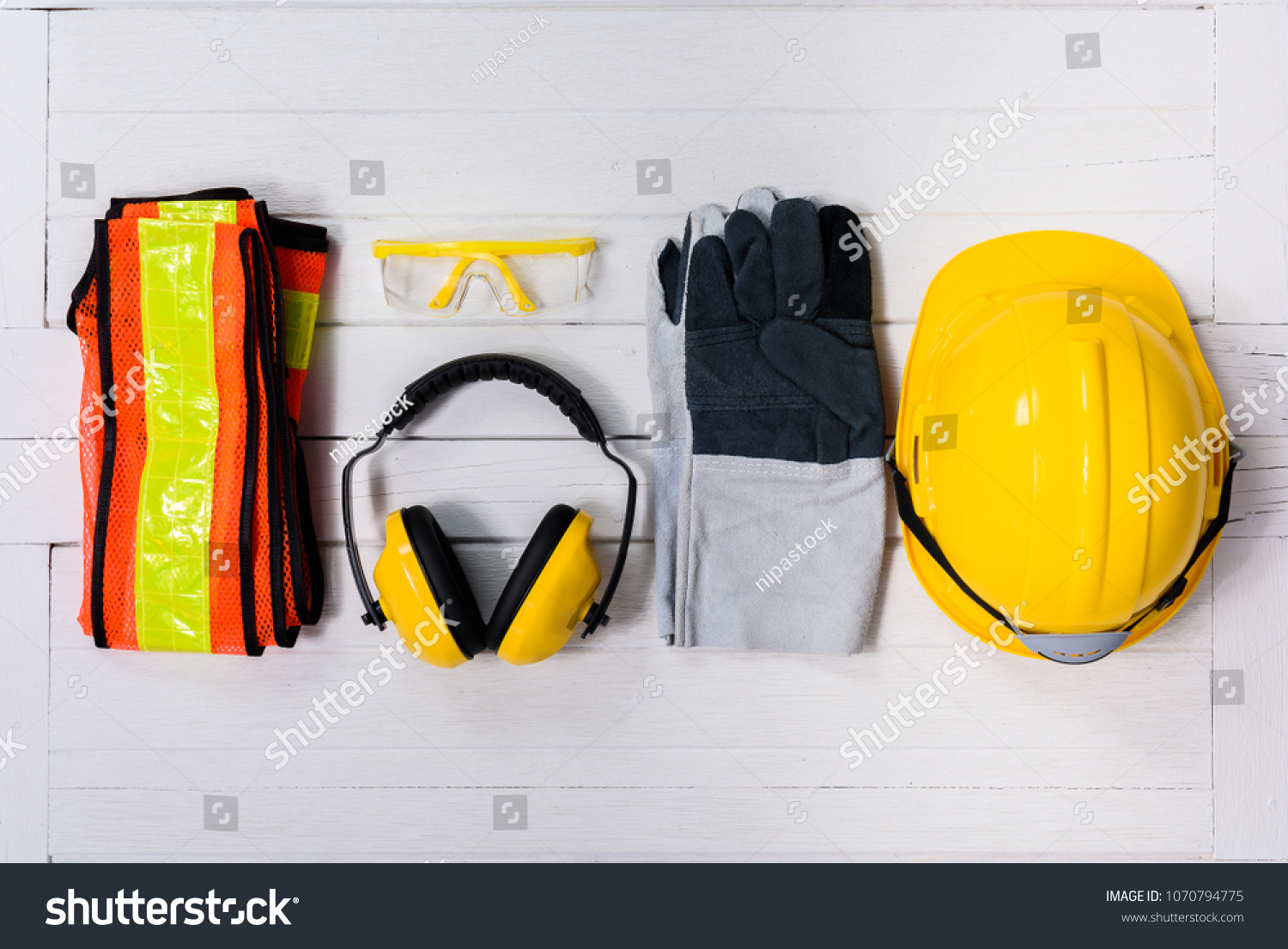 Standard construction safety equipment on white wooden background. top view, safety first concepts #1070794775