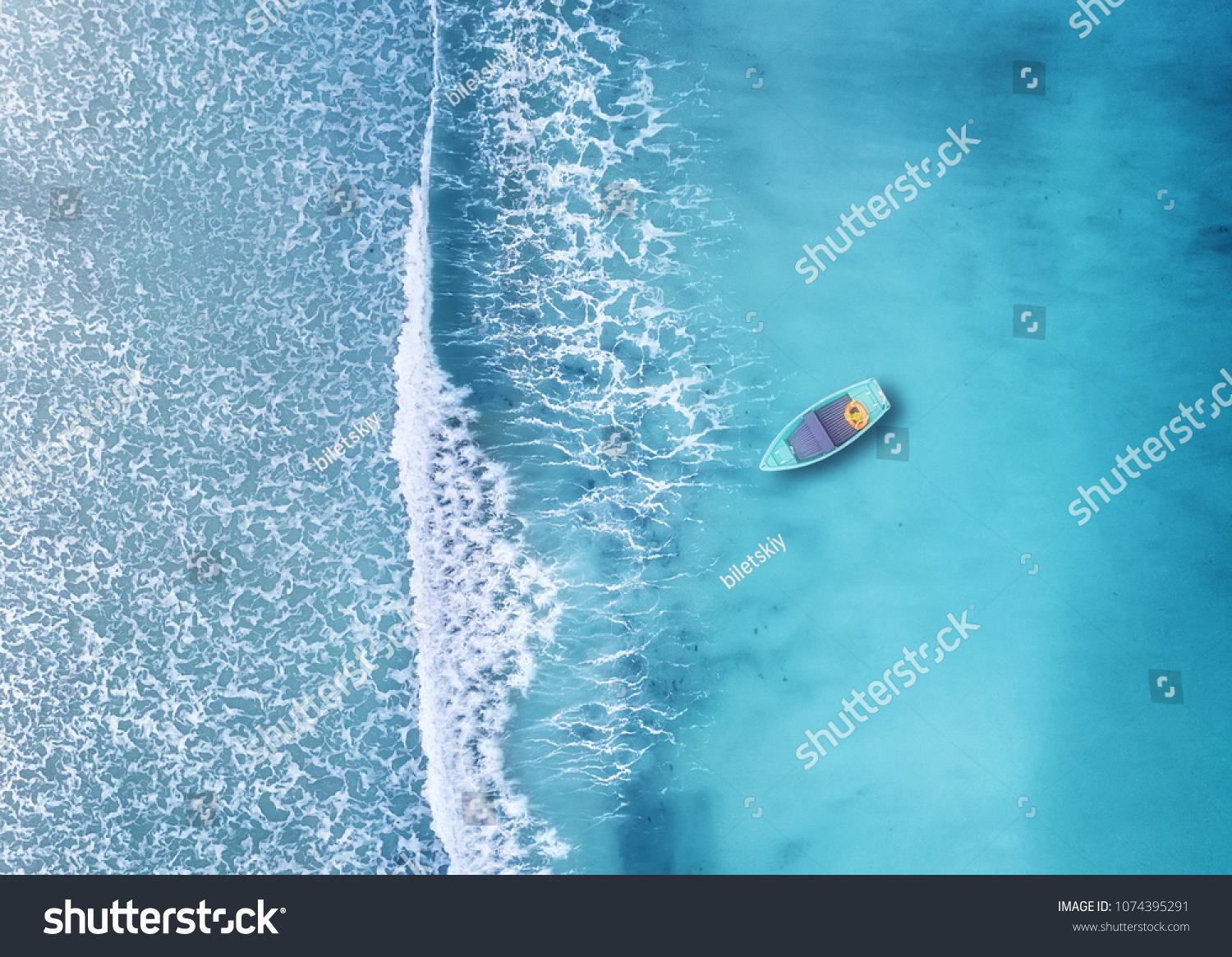 Fala i łódź na plaży jako tło. Piękne naturalne tło w okresie letnim z powietrza #1074395291