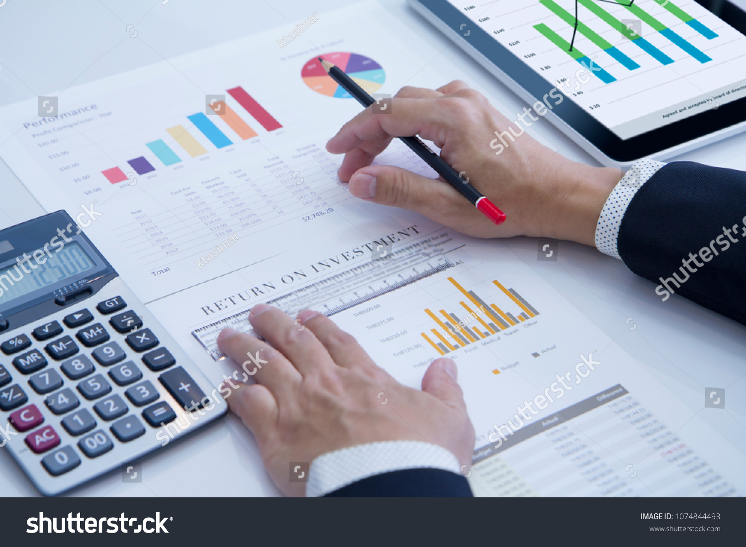 Businessman is deeply reviewing a financial report for a return on investment or investment risk analysis. #1074844493