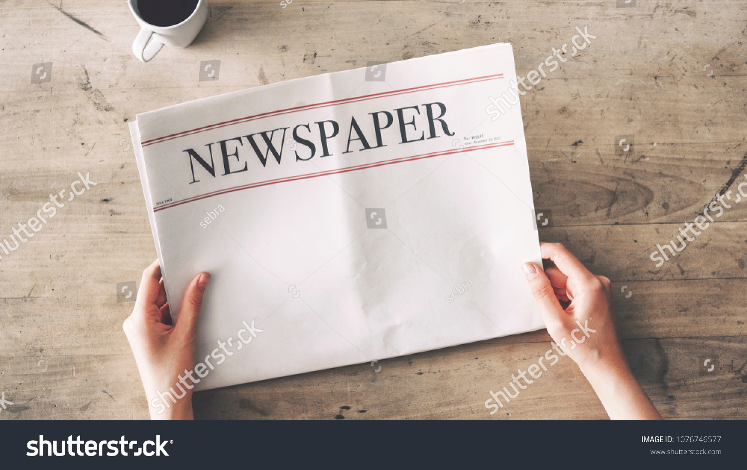 Woman reading newspaper on wooden background #1076746577
