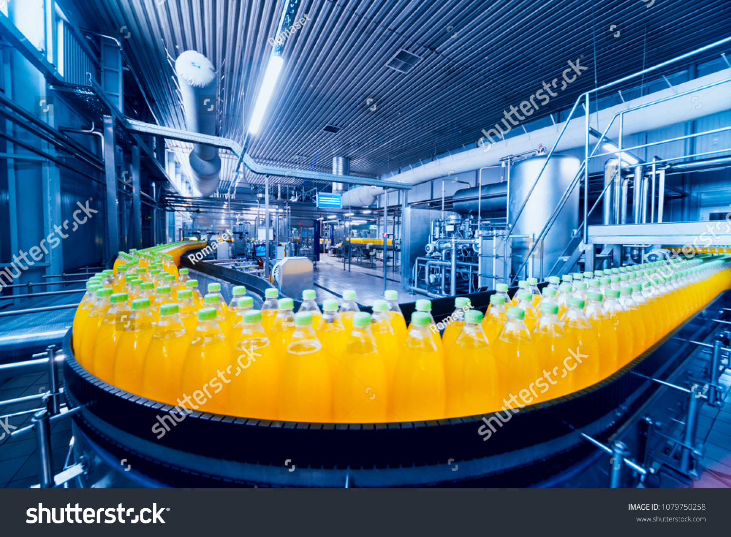 Beverage factory interior. Conveyor with bottles for juice or water. Modern equipments #1079750258