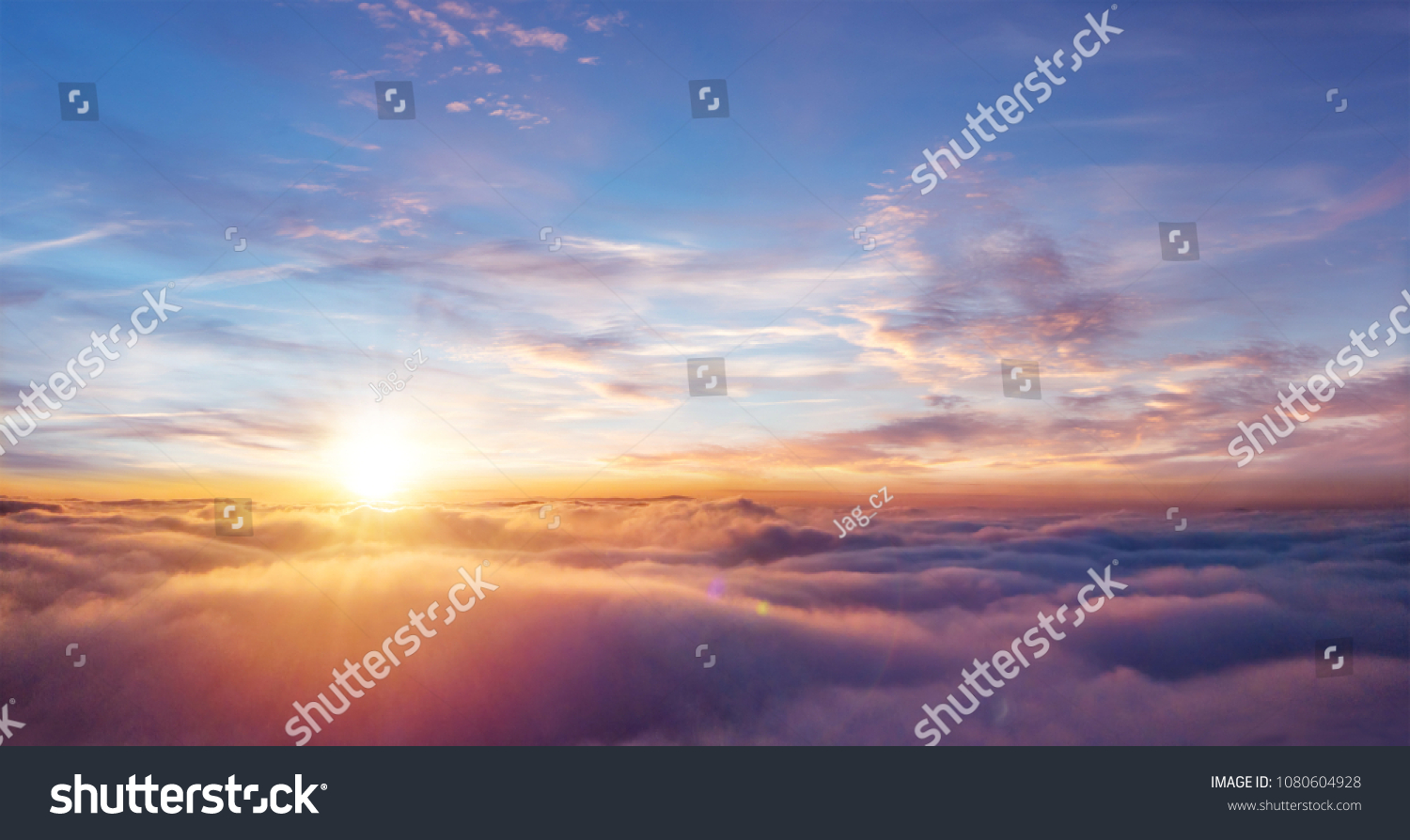Beautiful sunset sky above clouds with dramatic light. Cabin view from airplane #1080604928
