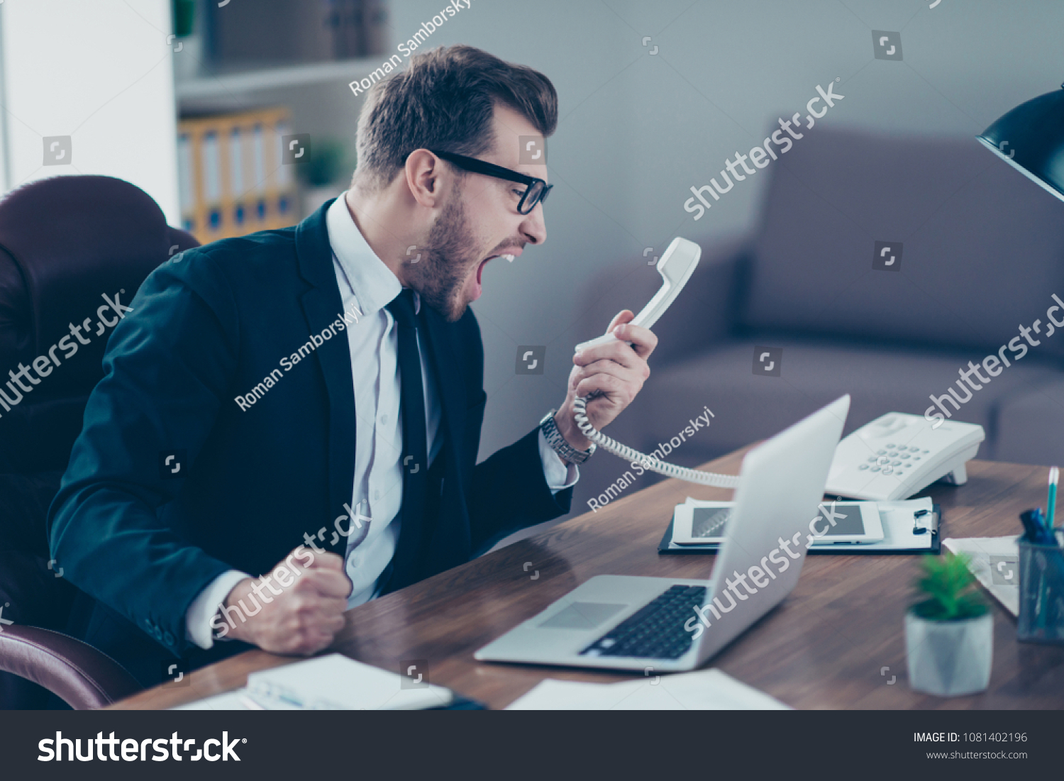Corporate mad people yell authority tell speak with staff people person concept. Side profile view portrait of disappointed tired busy sad upset agent financier shouting on receiver in his hand #1081402196