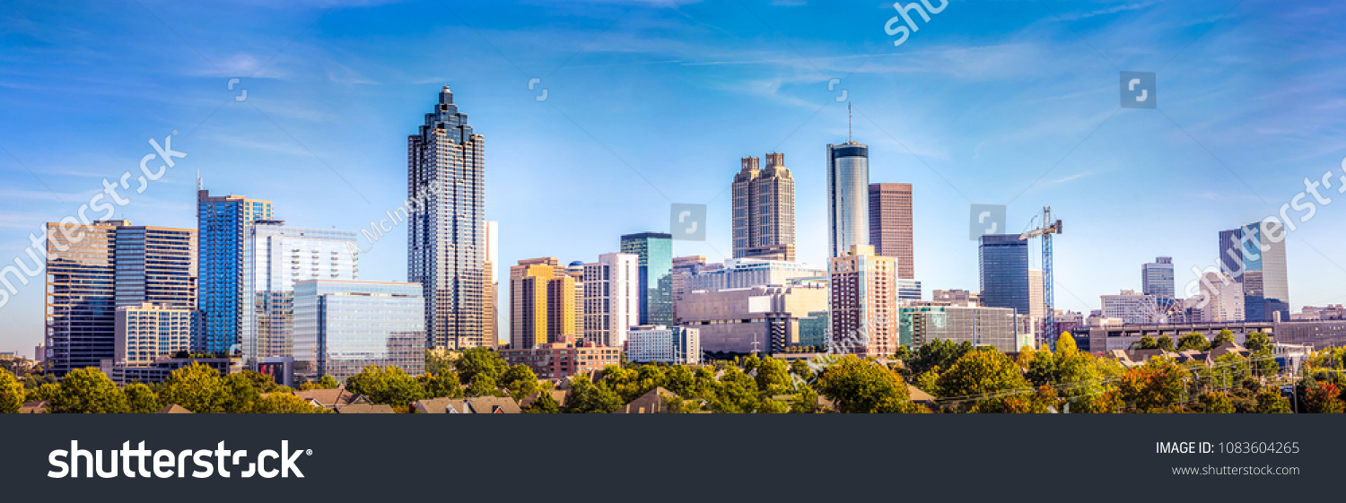 Downtown Atlanta Skyline showing several prominent buildings and hotels under a blue sky. #1083604265