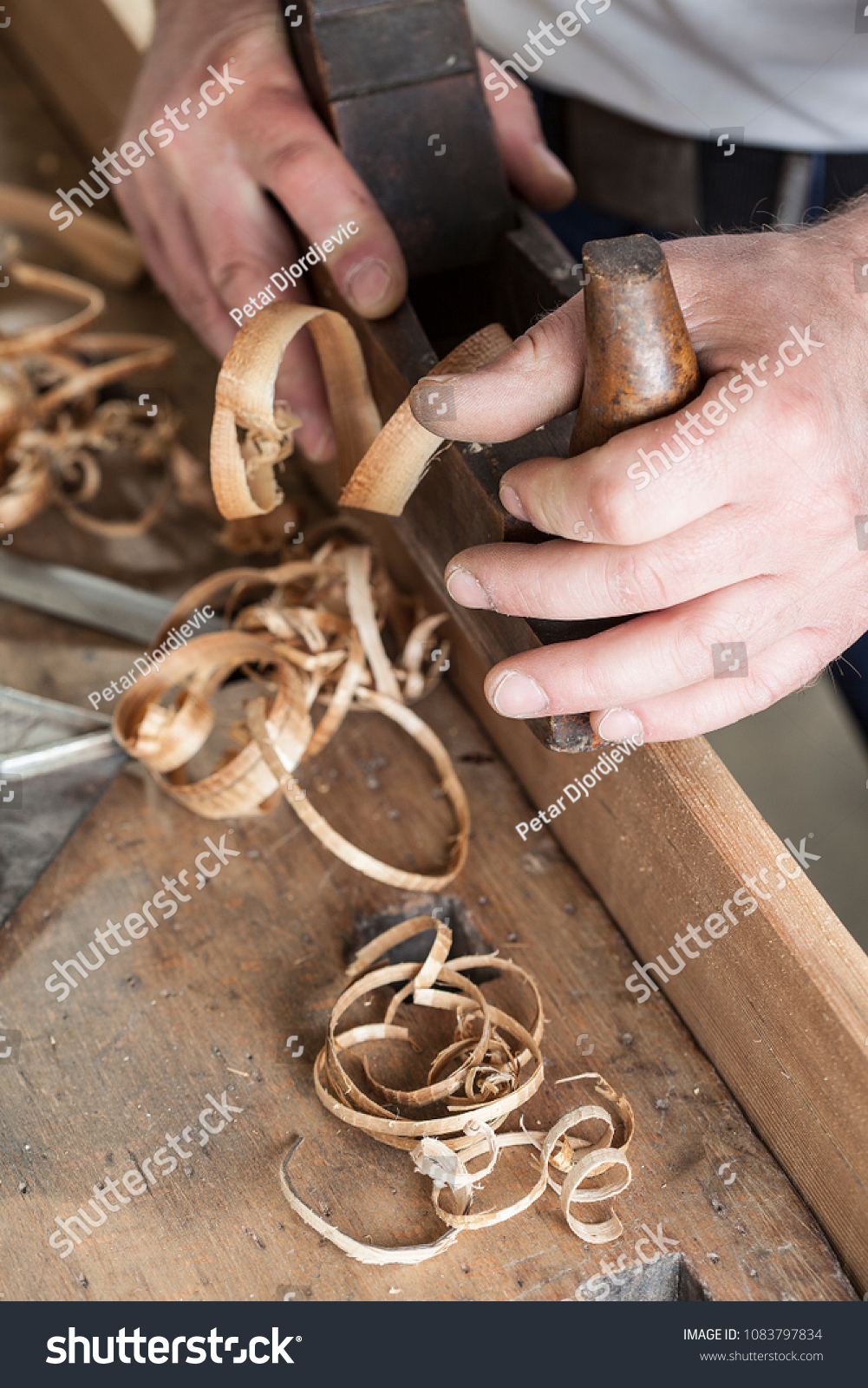 carpenter working with plane on wooden background #1083797834