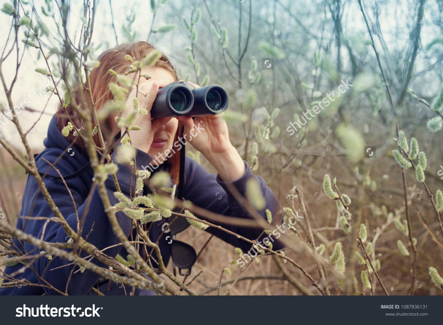 Girl with the binoculars against the background of the nature. Observation of birds. Birdwatching #1087836131