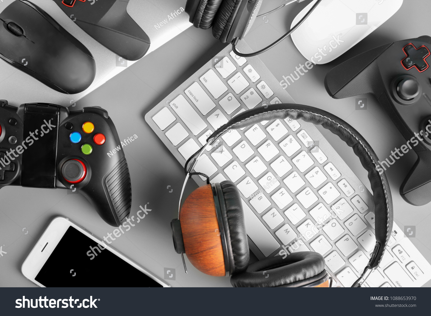 Gamepads, mice, headphones and keyboard on table #1088653970