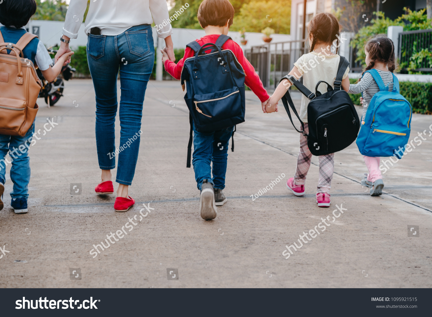 Mother and pupil and kids holding hands going to school in first class with schoolbag or satchel walking to school bus, Parent and son,sister preschool  #1095921515