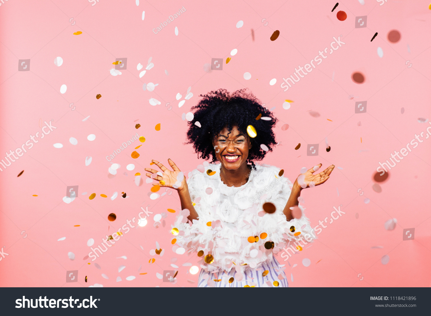 Celebrating happiness, young woman with big smile throwing confetti	
 #1118421896