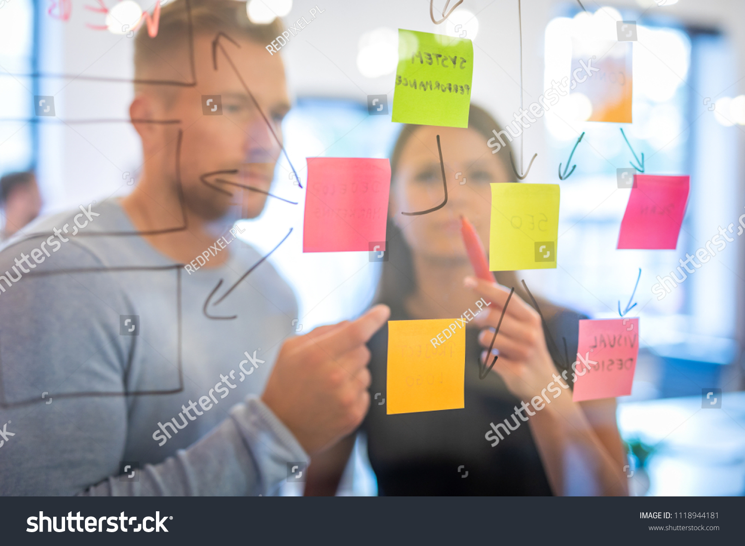 Business people meeting at office and use post it notes to share idea. Brainstorming concept. Sticky note on glass wall. #1118944181