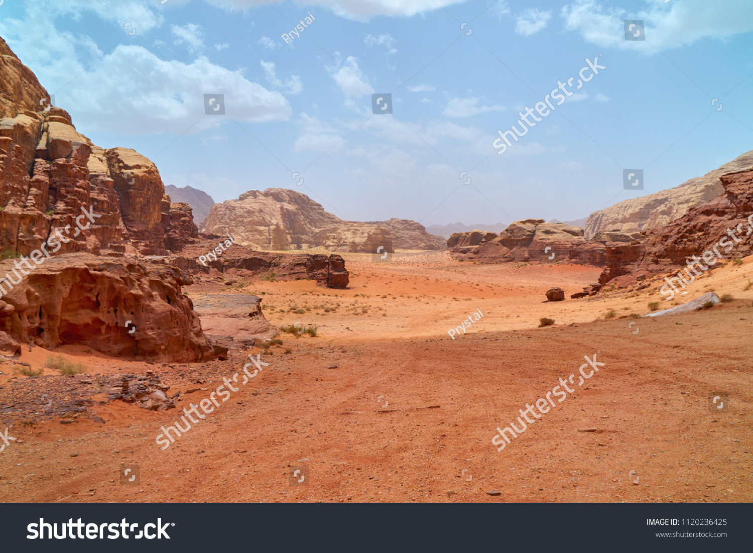 Wadi Rum desert, Jordan, The Valley of the Moon. Orange sand, haze, clouds. Designation as a UNESCO World Heritage Site. Red planet Mars  landscape. Offroad adventures travel background.               #1120236425