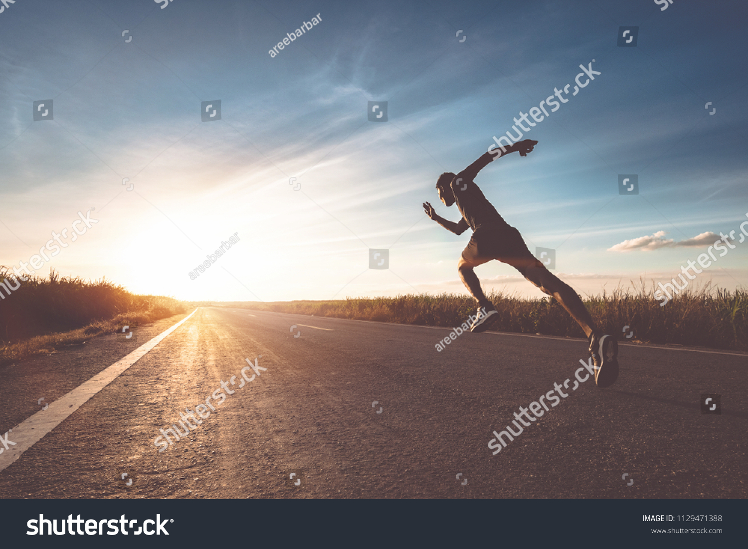 The man with runner on the street be running for exercise. #1129471388