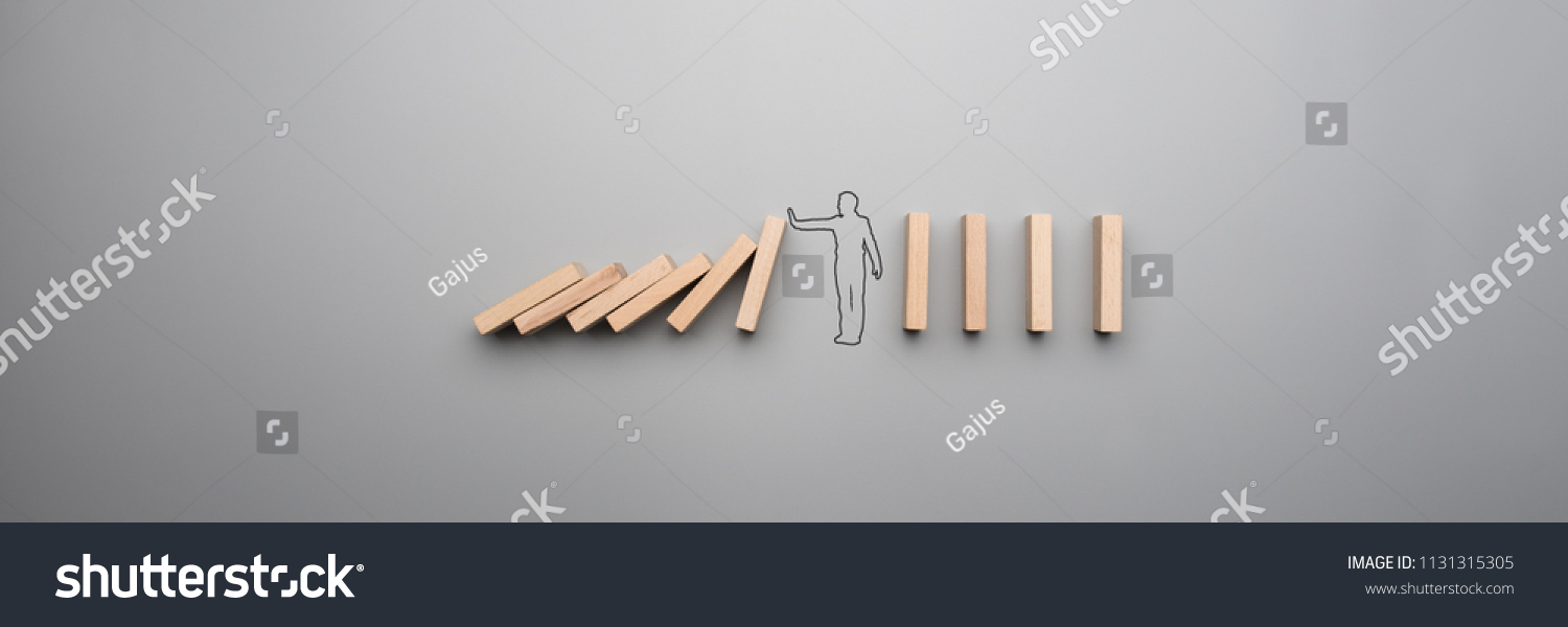 Wide cropped image of the outline of a businessman stopping the domino effect on gray background. #1131315305