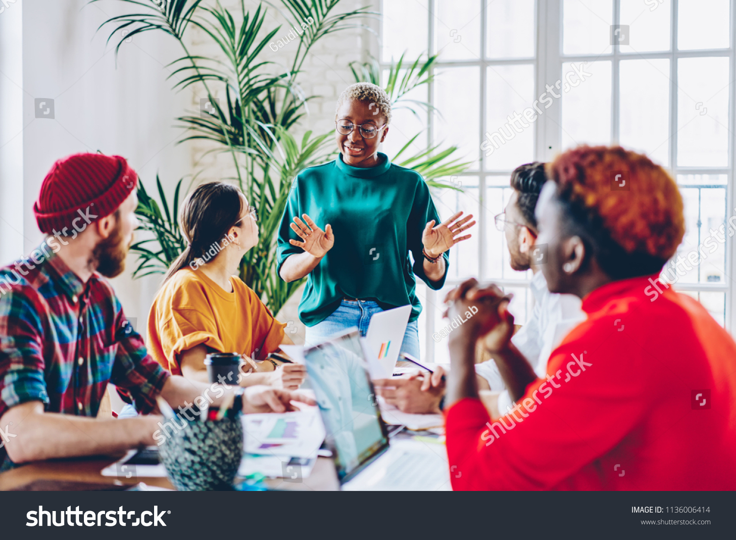 African american female coach speaking during workshop with crew of students explaining strategy in business school, creative dark skinned woman share her opinion with colleagues during work #1136006414