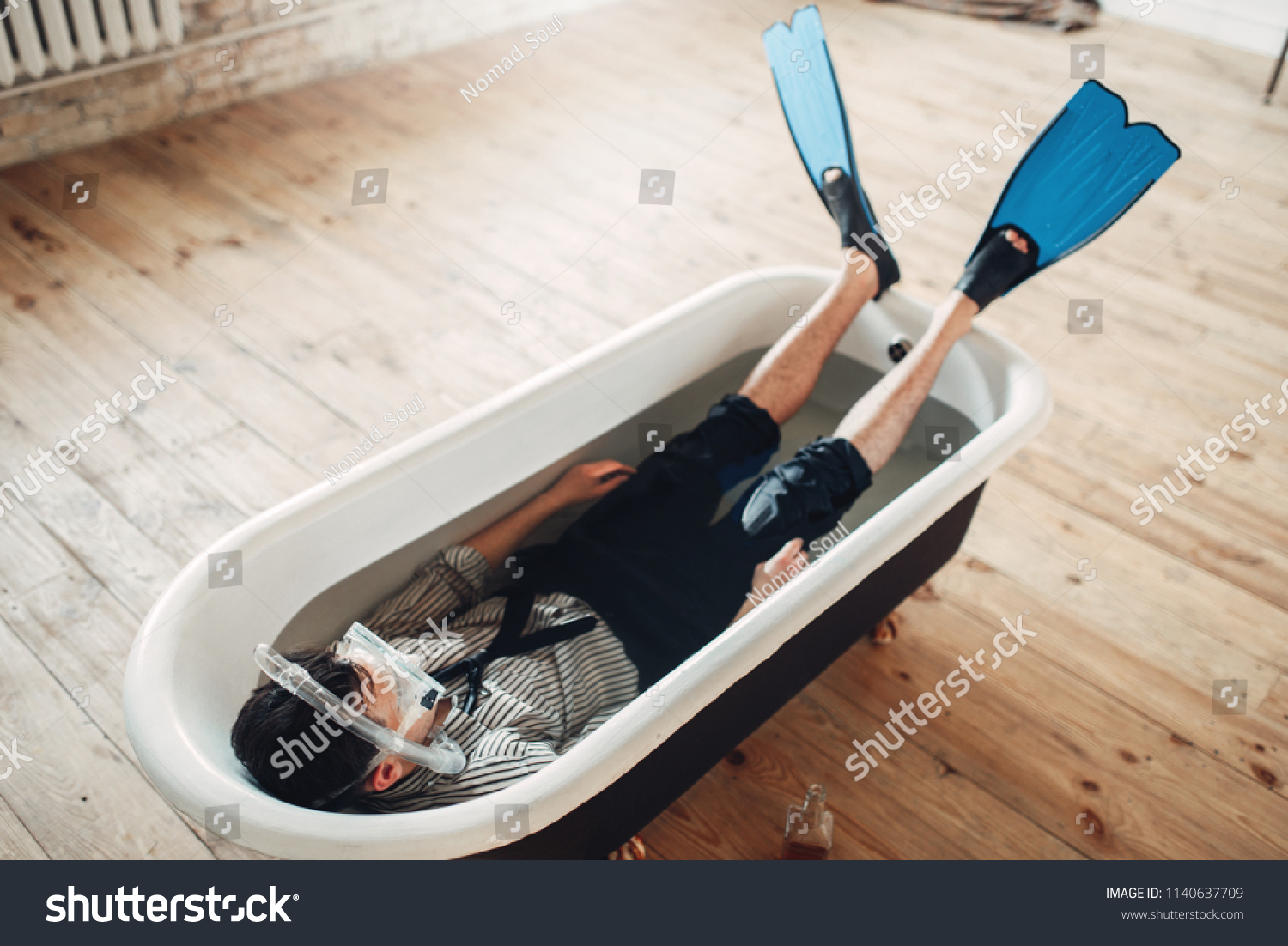 Businessman in flippers and mask lies in bathtub #1140637709