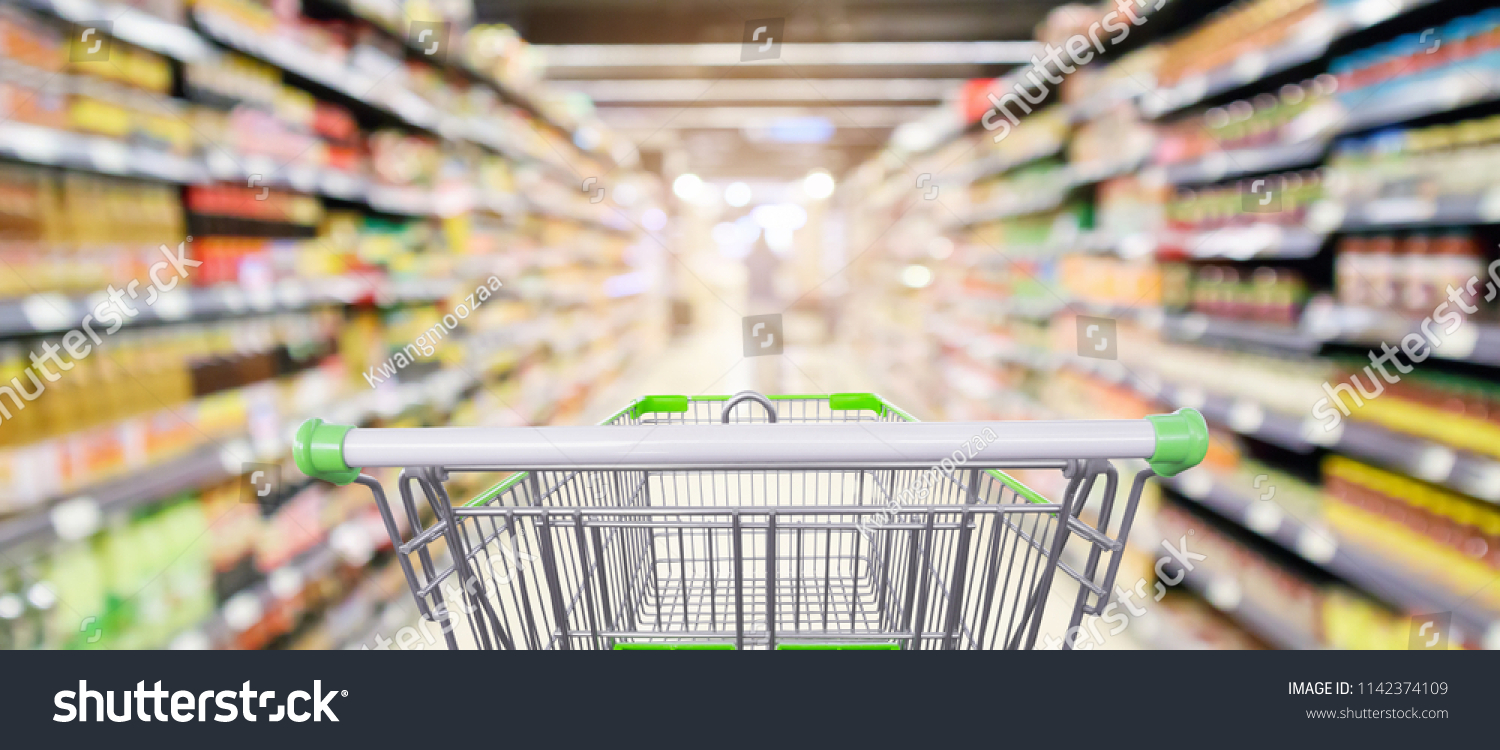 supermarket shelves aisle with empty shopping cart defocused interior blur bokeh light background #1142374109