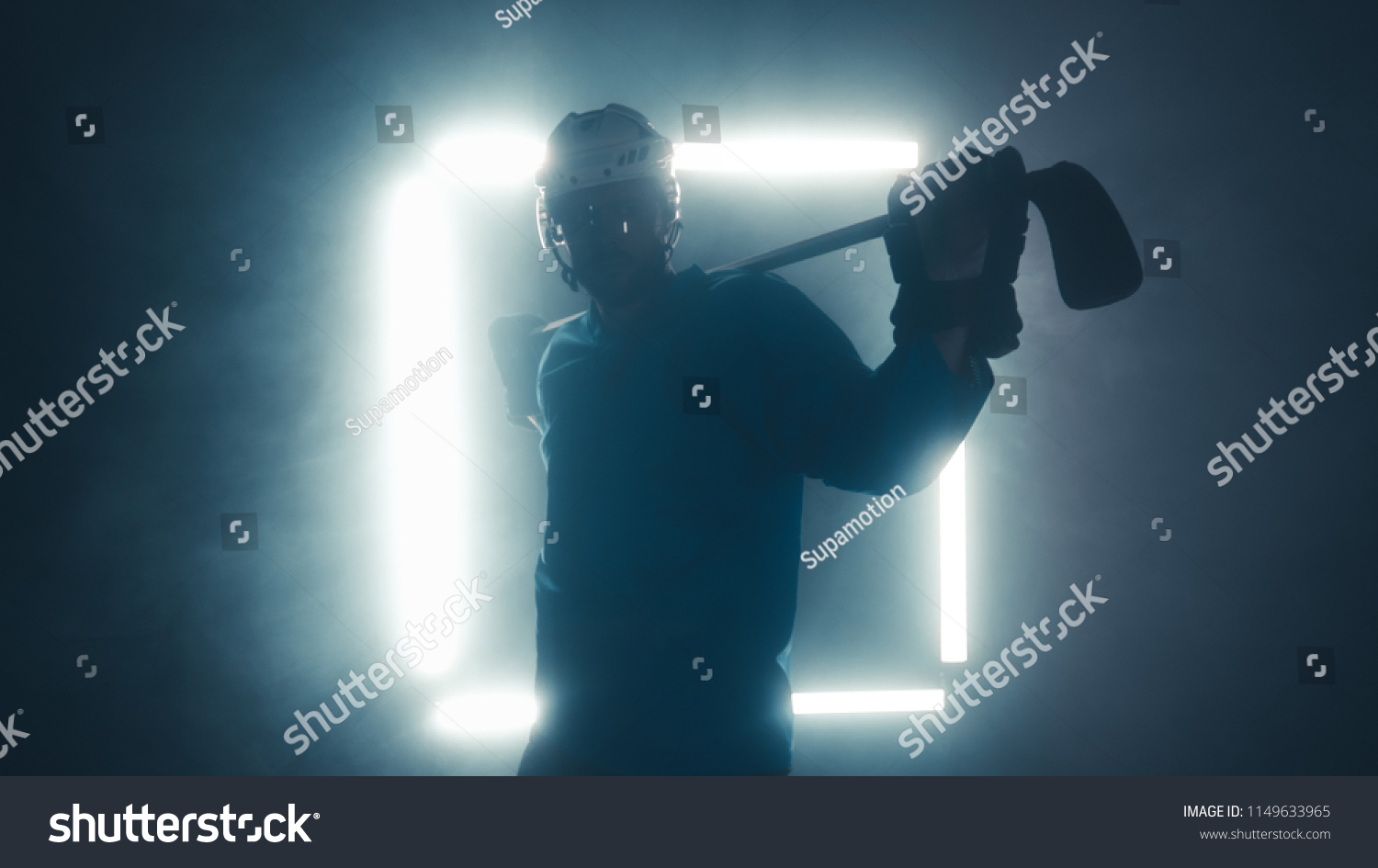 Portrait of Caucasian male ice hockey player in uniform, looking into the camera, dramatic lighting #1149633965