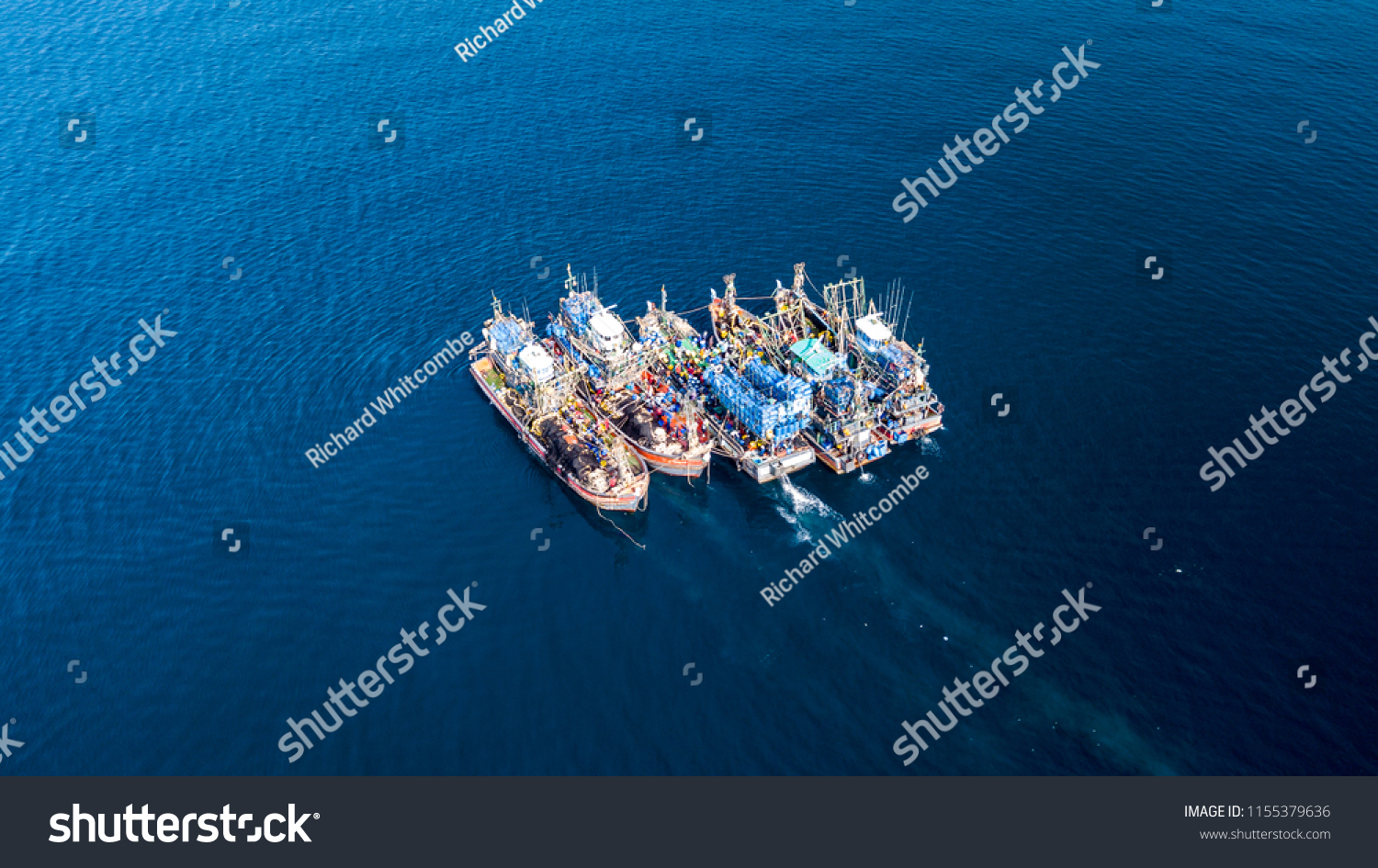 Aerial view of a large number of fishing trawlers operating together illegally in a marine reserve #1155379636