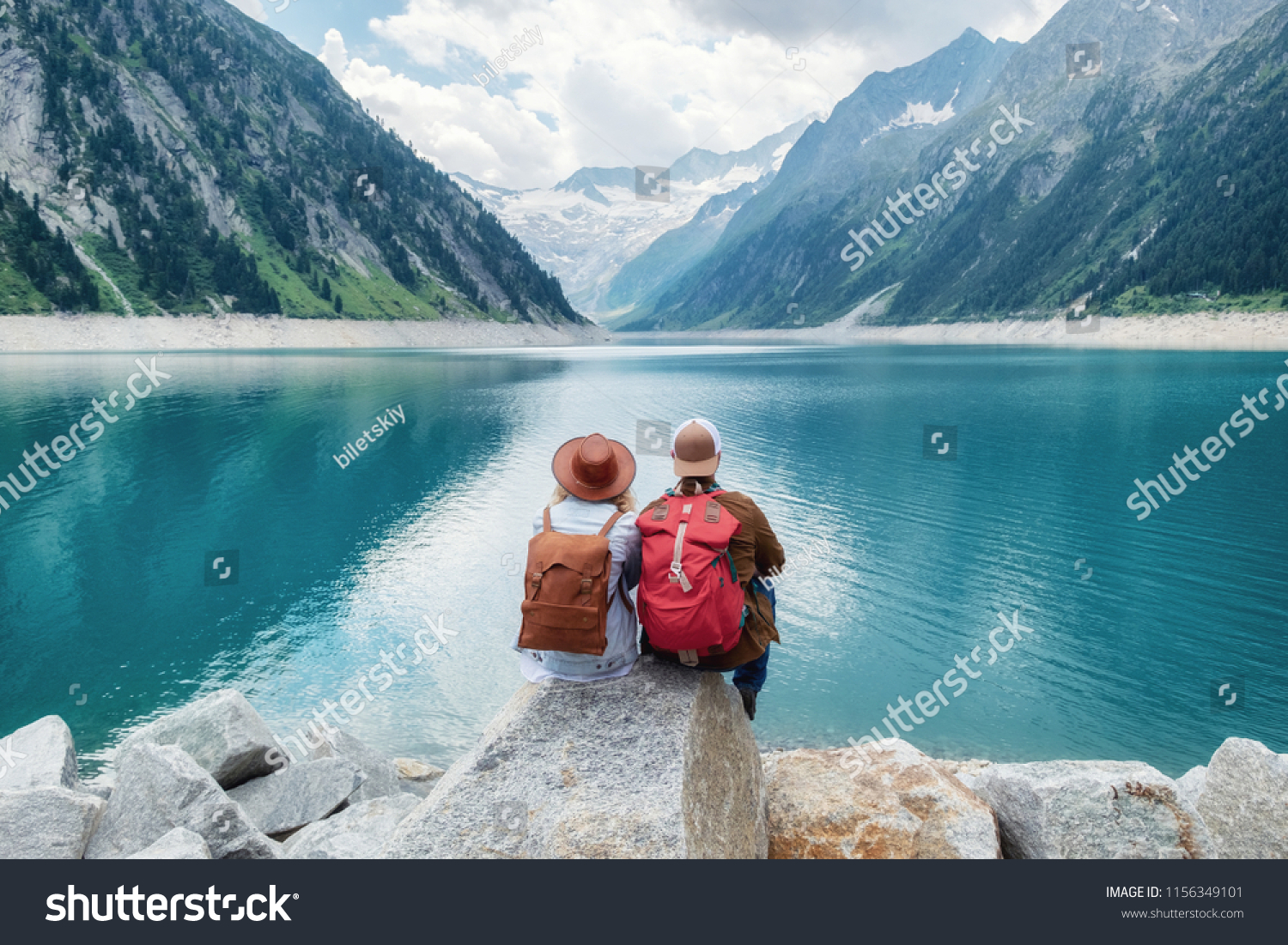 Travelers couple look at the mountain lake. Travel and active life concept with team. Adventure and travel in the mountains region in the Austria #1156349101