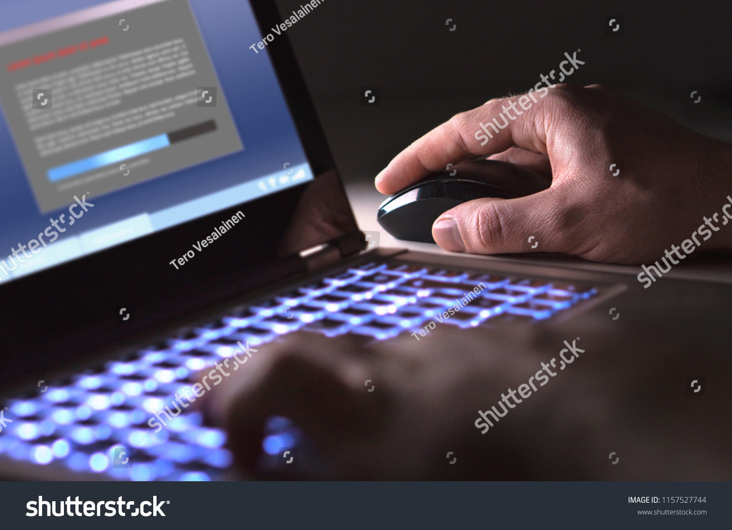 Man installing software in laptop in dark at night. Hacker loading illegal program or guy downloading files. Cyber security, piracy or virus concept. #1157527744