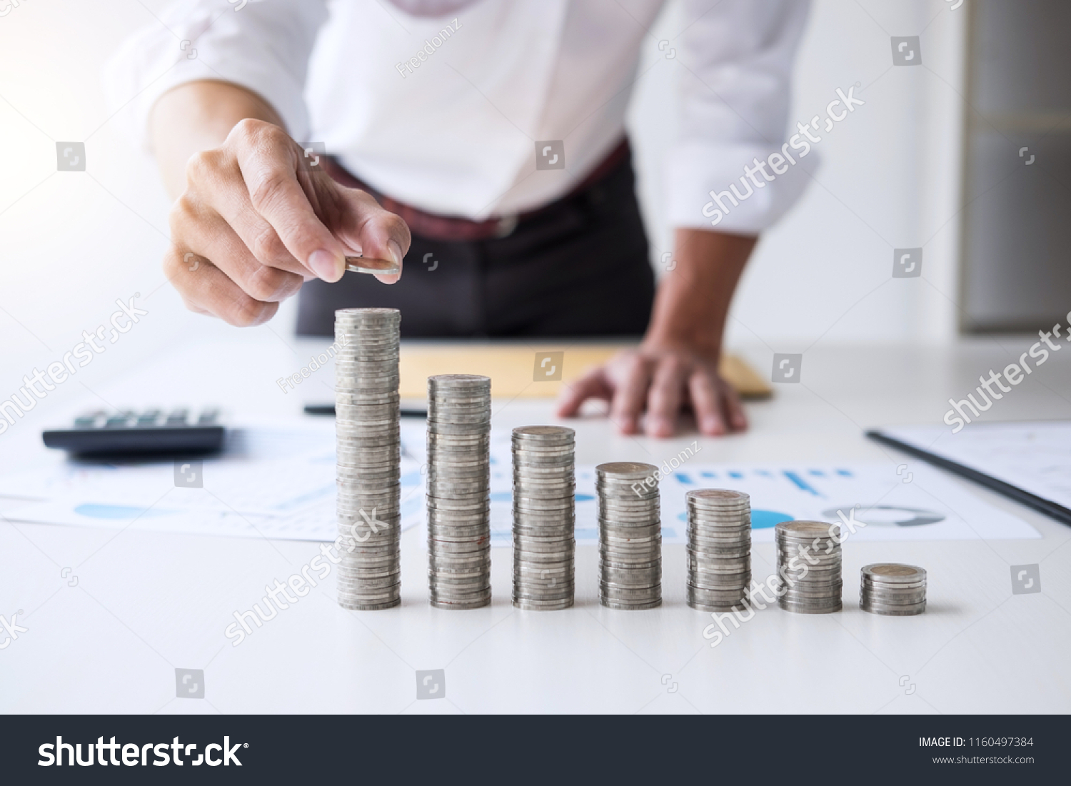 Business accountant or banker, businessman calculate and analysis with stock financial indices and putting growth stacking coin and financial costs wisely and carefully, investment and saving concept. #1160497384