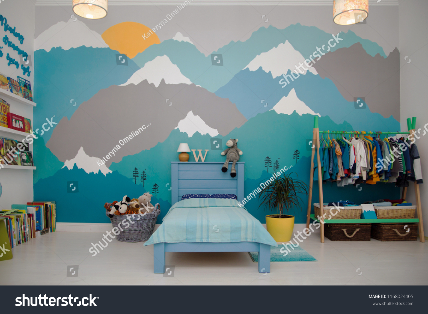 A spacious boy bedroom with a beautiful turquoise and grey mountain wall mural and bookshelves #1168024405