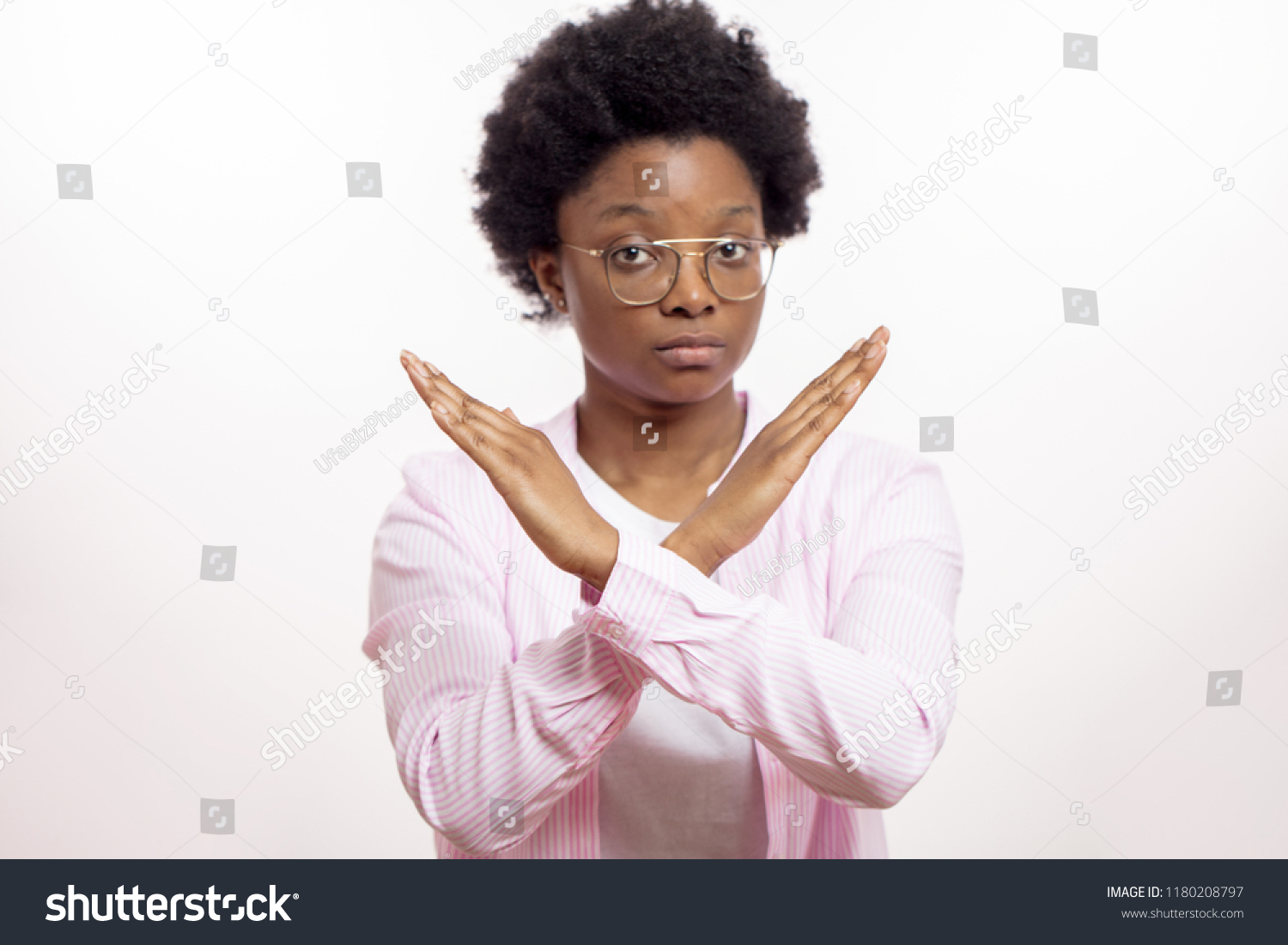 serios mixed race woman says no isolated on white background. severe afro female with crossing arms expressing her negative attitude to smoking #1180208797