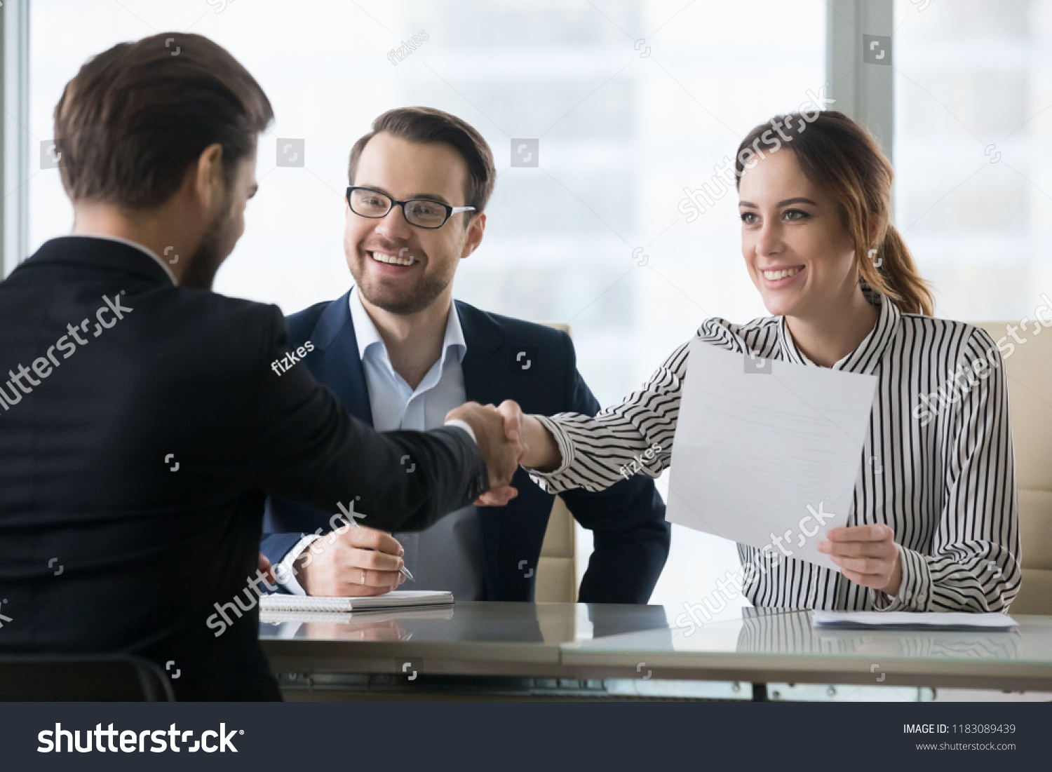 Happy employers shake hand of male job candidate, congratulating with given position, satisfied HR managers happy to hire applicant handshake greeting at team. Successful good interview concept #1183089439