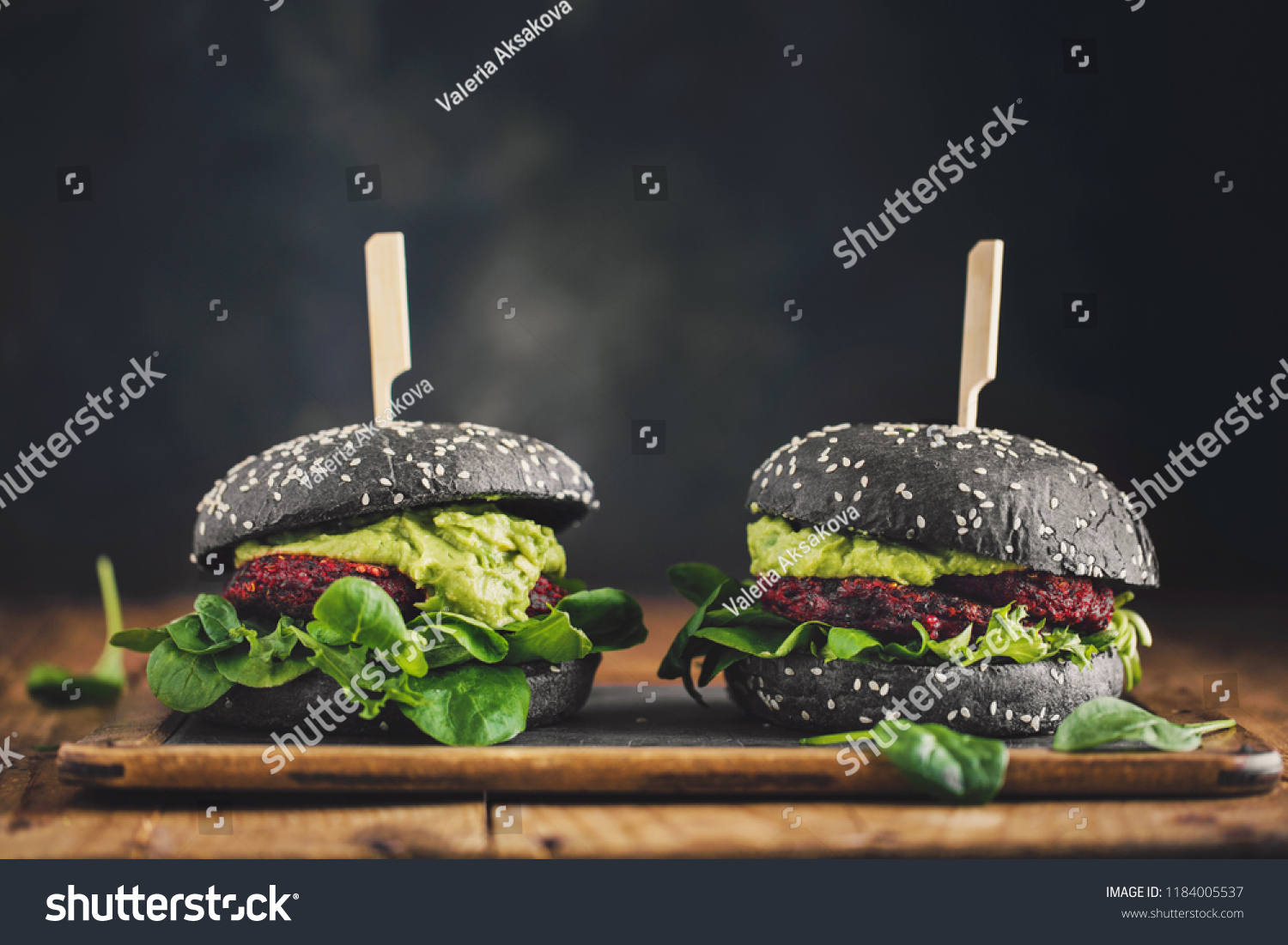 Tasty appetizing healthy vegan black burgers with beetroot, quinoa and avocado sauce served on wooden table. Horizontal with copy space. Concept of healthy food, clean eating #1184005537