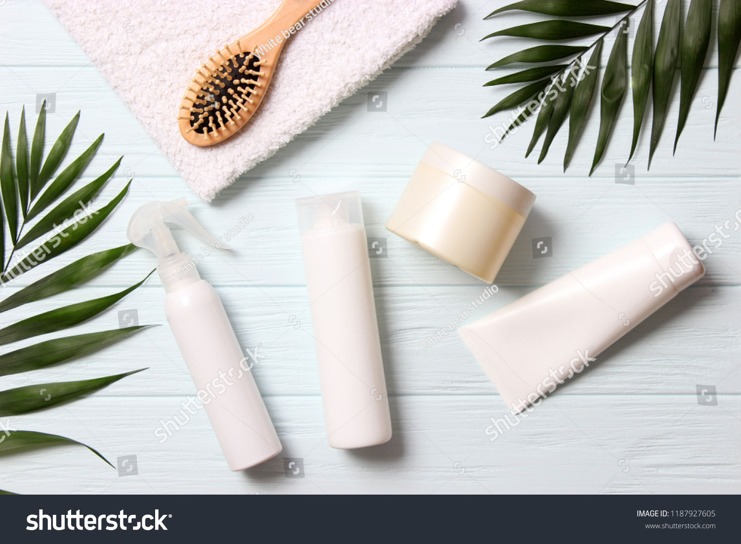 natural hair care products, hairbrush, towel and leaves on a wooden background top view. Shampoo, mask, balm. flatlay #1187927605