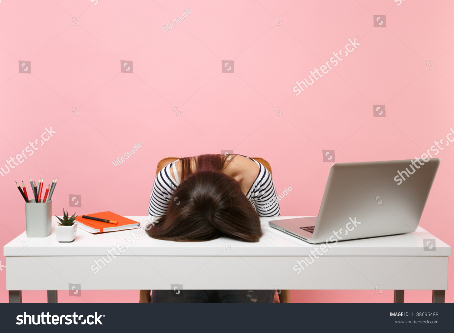 Young frustrated exhausted woman laid her head down on the table sit work at white desk with contemporary pc laptop isolated on pastel pink background. Achievement business career concept. Copy space #1188695488