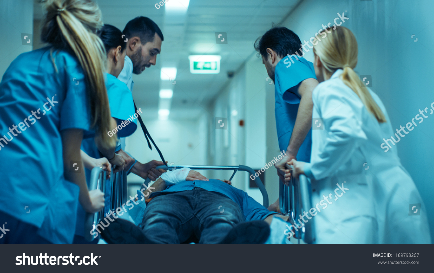 Emergency Department: Doctors, Nurses and Surgeons Move Seriously Injured Patient Lying on a Stretcher Through Hospital Corridors. Medical Staff in a Hurry Move Patient into Operating Theater. #1189798267