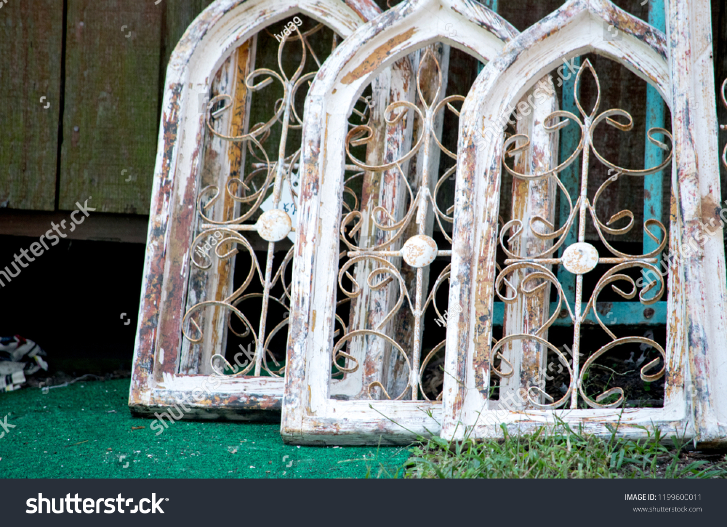 arched wooden windows at a salvage yard #1199600011