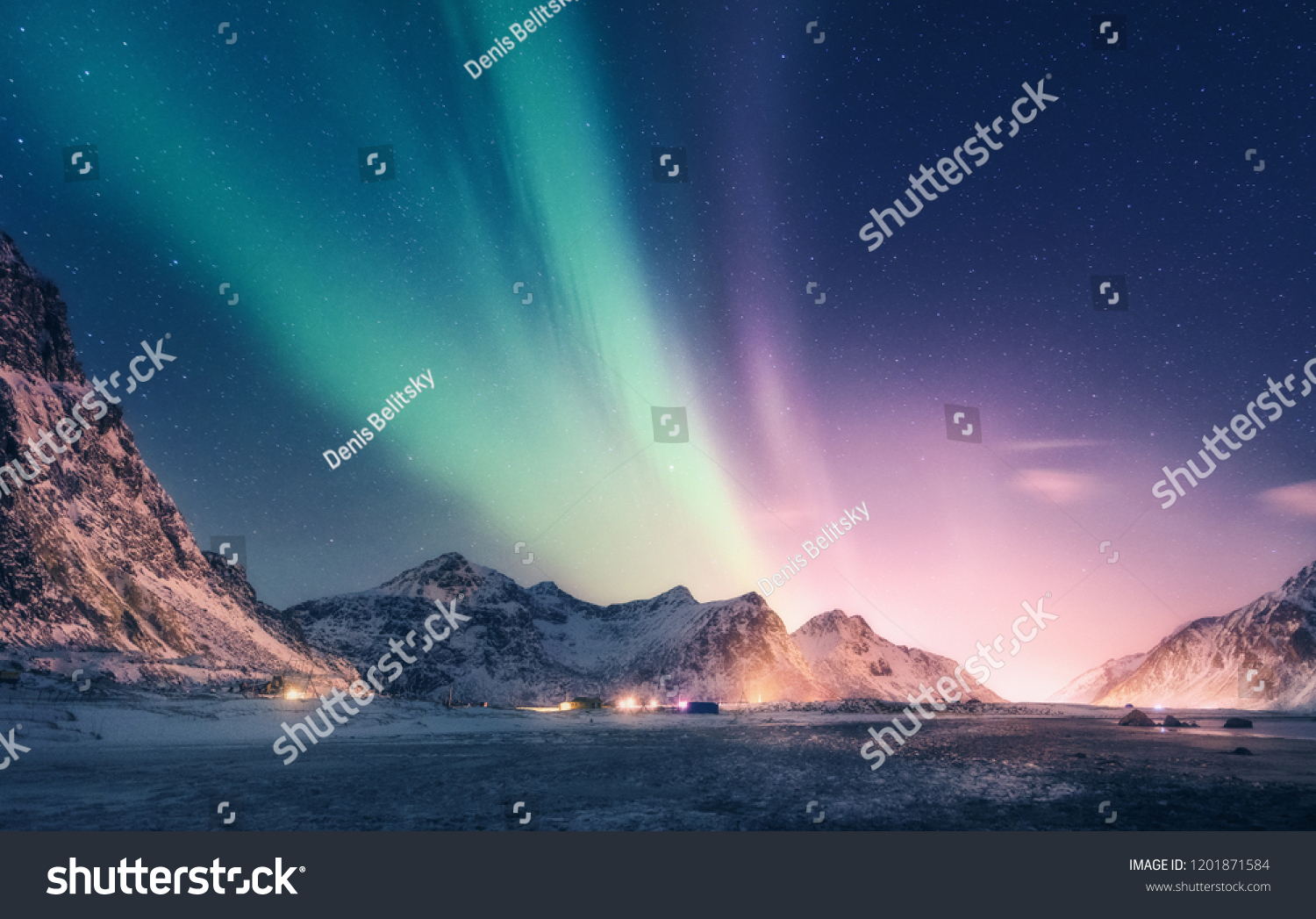 Green and purple aurora borealis over snowy mountains. Northern lights in Lofoten islands, Norway. Starry sky with polar lights. Night winter landscape with aurora, high rocks, beach. Travel. Scenery #1201871584