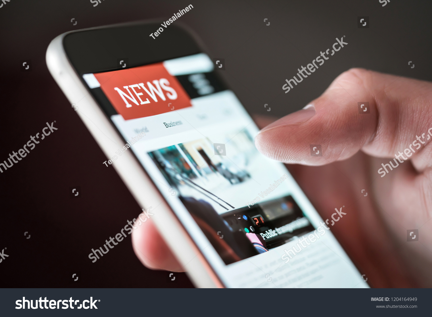 Mobile news application in smartphone. Man reading online news on website with cellphone. Person browsing latest articles on the internet. Light from phone screen. #1204164949
