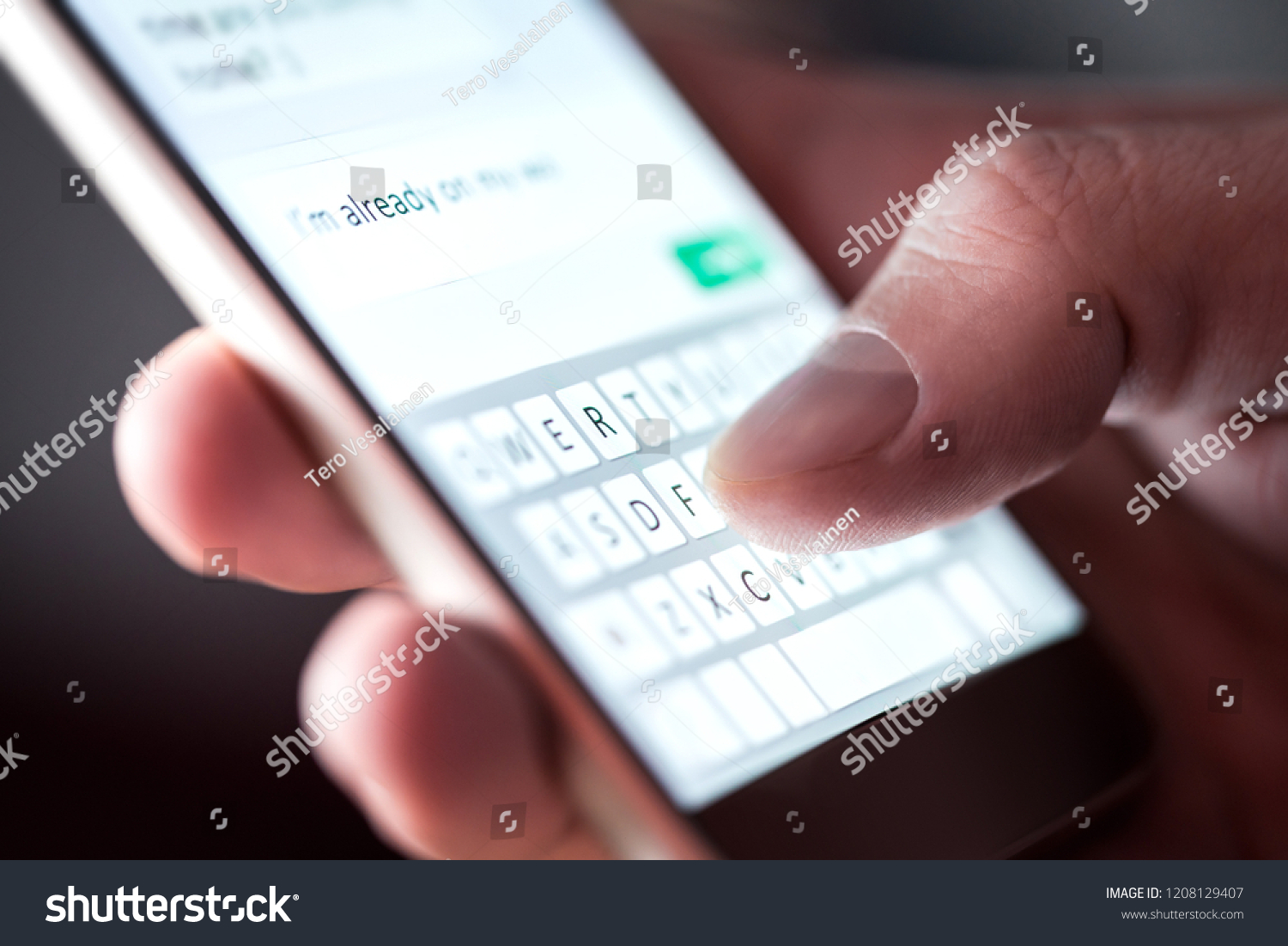 Man sending text message and sms with smartphone. Guy texting and using mobile phone late at night in dark. Communication or sexting concept. Finger typing with cellphone keyboard. Light from screen. #1208129407