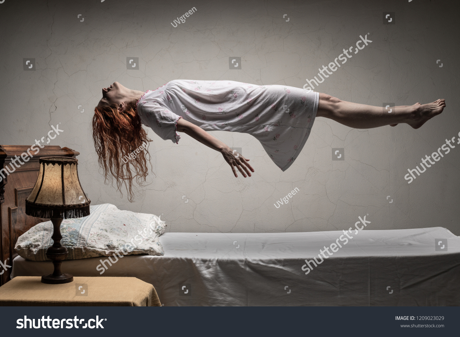 Woman levitating over bed / astral traveling, nightmare, excorcist halloween concept #1209023029