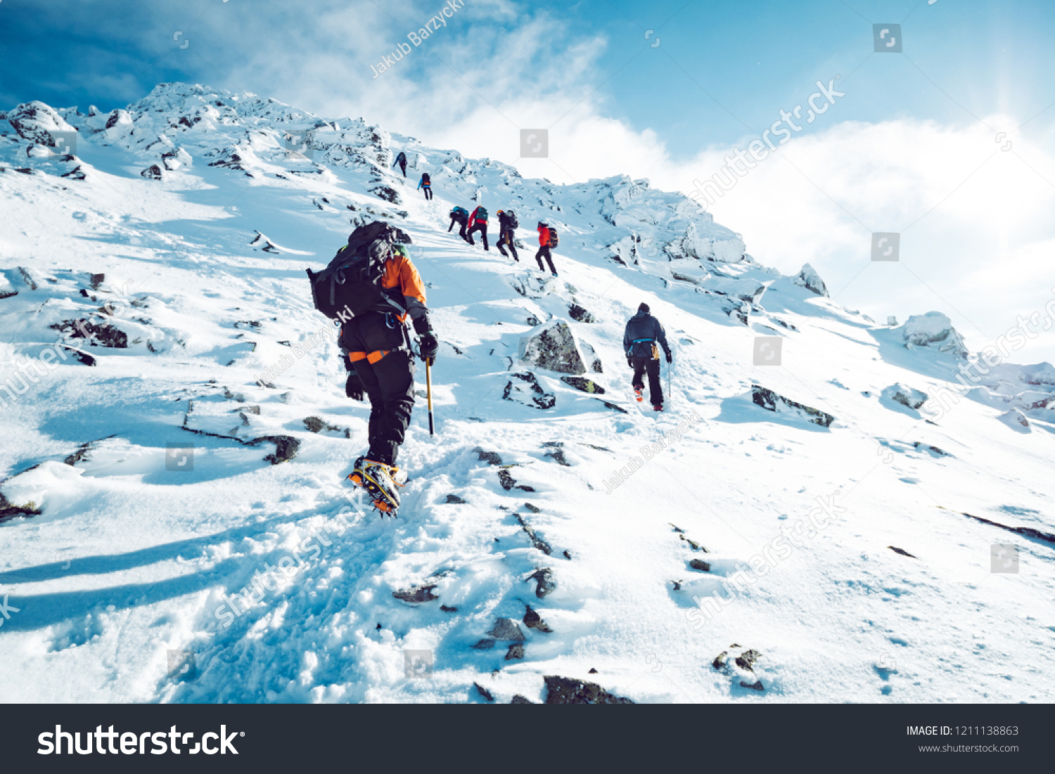 A group of climbers ascending a mountain in winter #1211138863