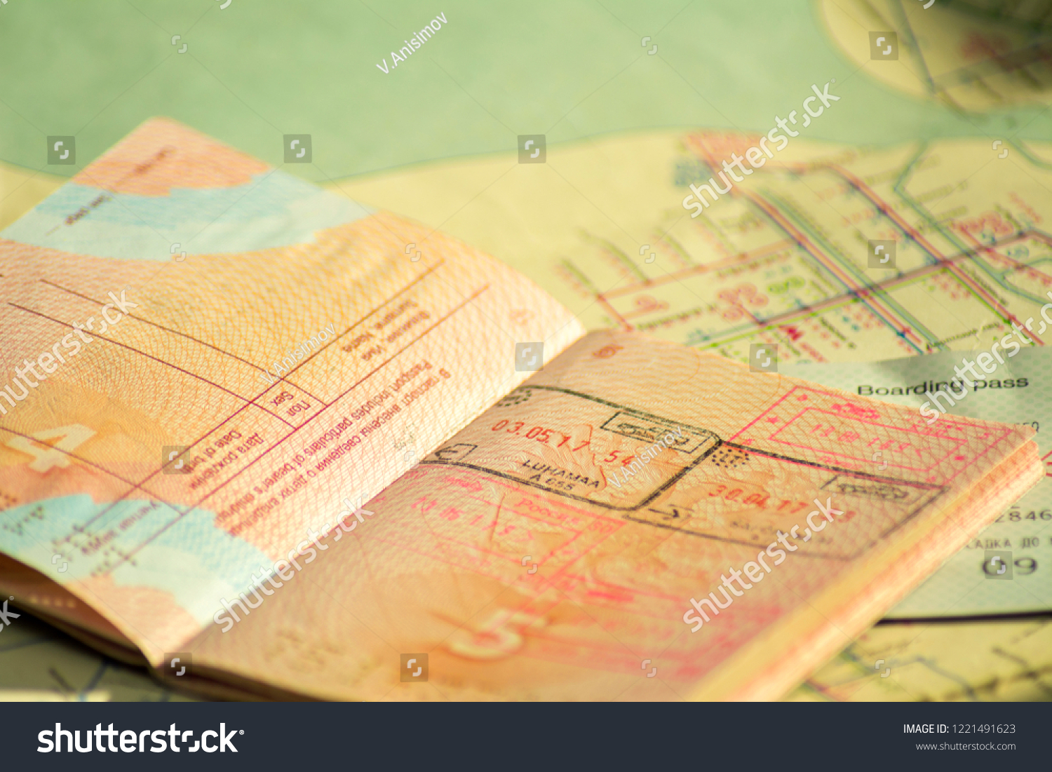 The concept of travel. Russian passport with visas. Passport and plane ticket is on the old map. Sunlight and shadow #1221491623