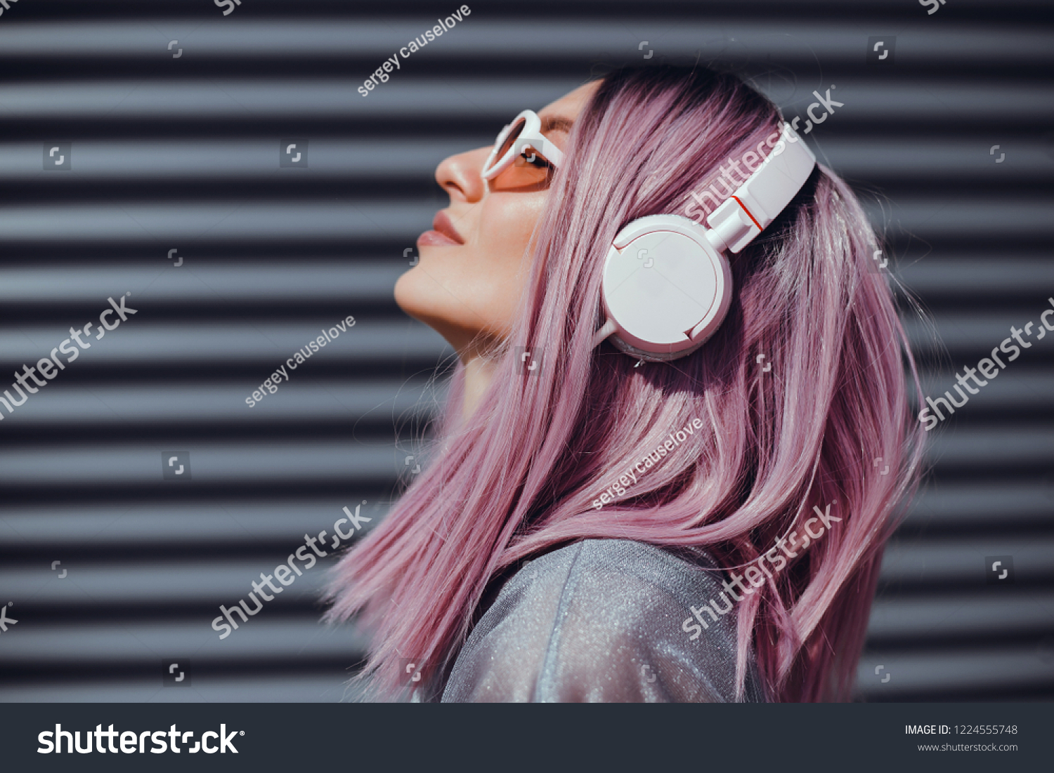 Beautiful young girl with purple pink hair listening to music on headphones, street style, outdoor portrait, hipster girl, music, mp3, Bali, beauty woman, sunglasses, orange color, concept #1224555748
