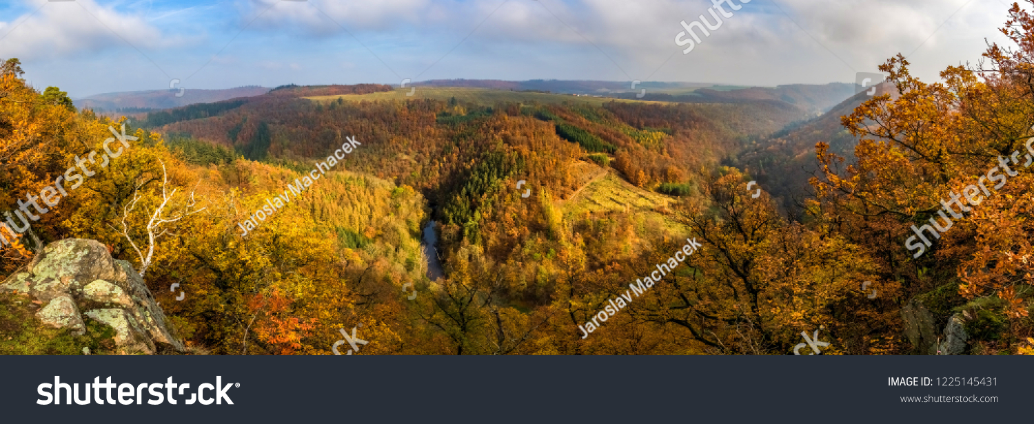 Panoramic view of beautiful autumnal landscape with river valley, colorful forests, blue sky and clouds - Oslava river, Czech Republic, Europe #1225145431