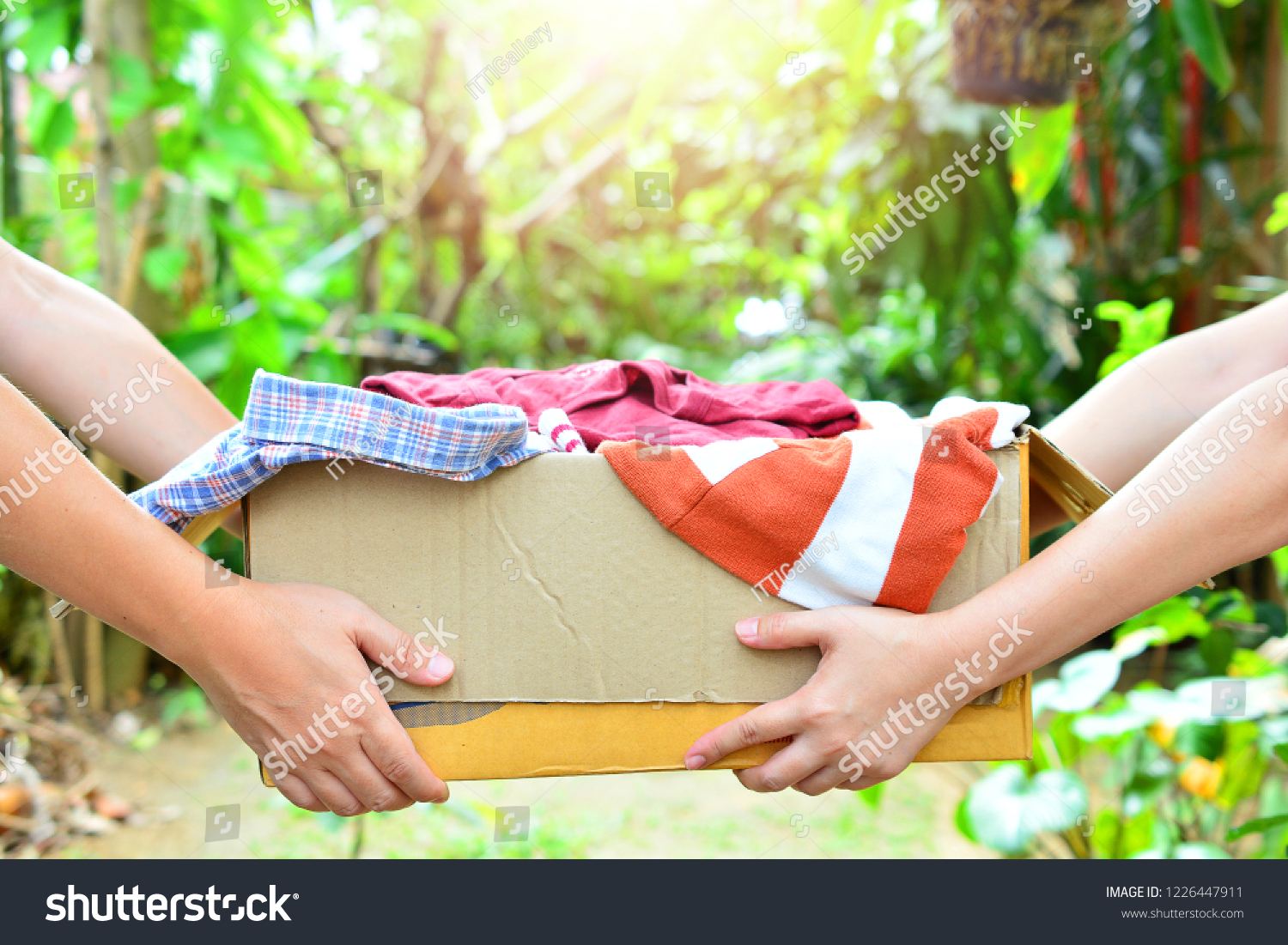 hand holding box give clothes together for concept donation and reuse recycle #1226447911