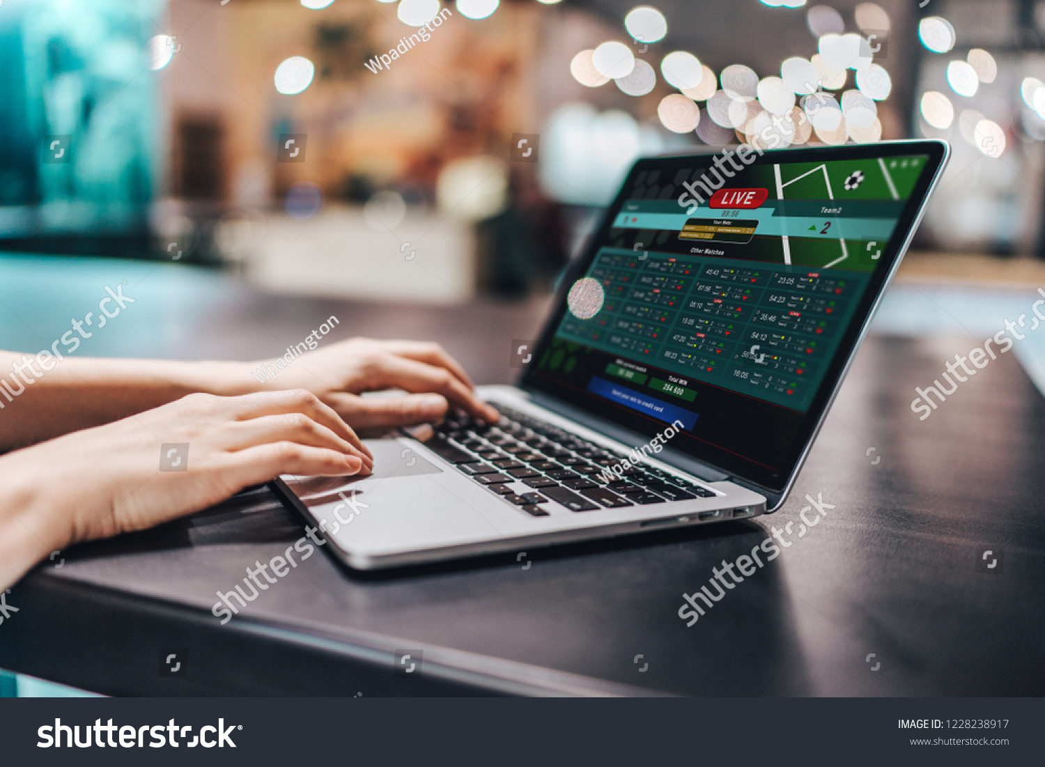 Close up crooped shot of female hands using laptop. Girl sitting in loft coffee shop and making bets online on sport bookmaker's webcite. #1228238917