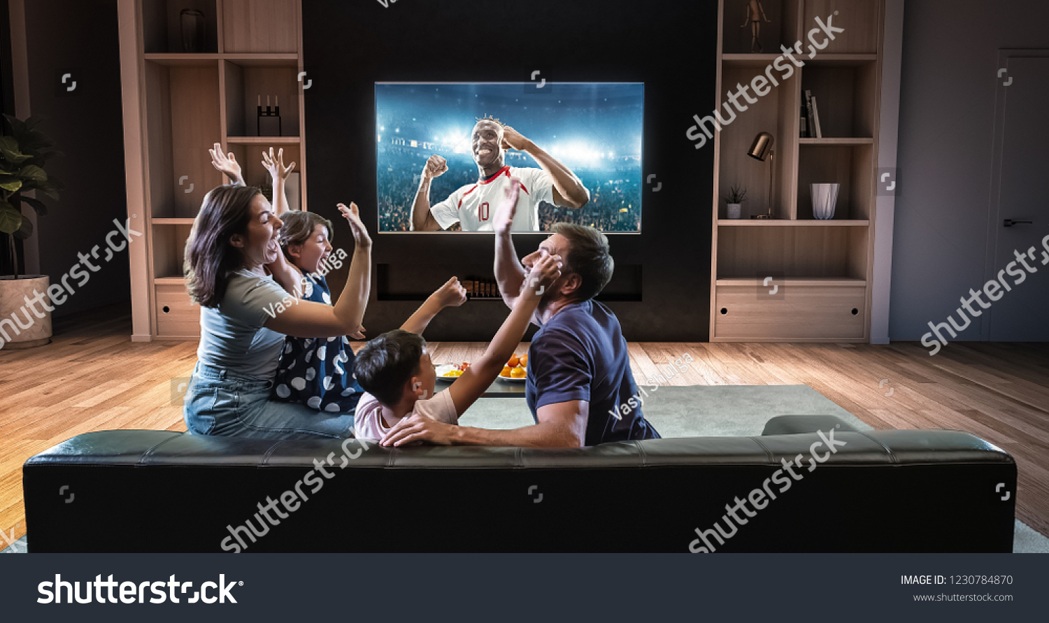 A family is watching a soccer moment on the TV and celebrating a goal, sitting on the couch in the living room. The living room is made in 3D. #1230784870
