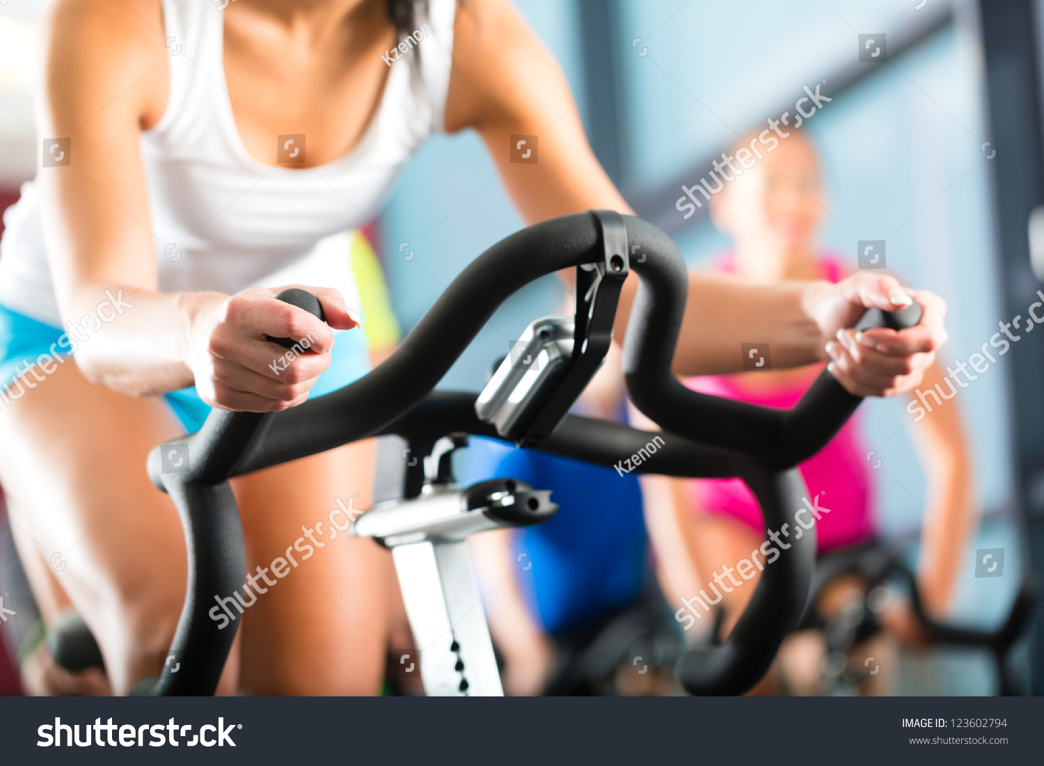 Young People - group of women and men - doing sport biking in the gym for fitness #123602794