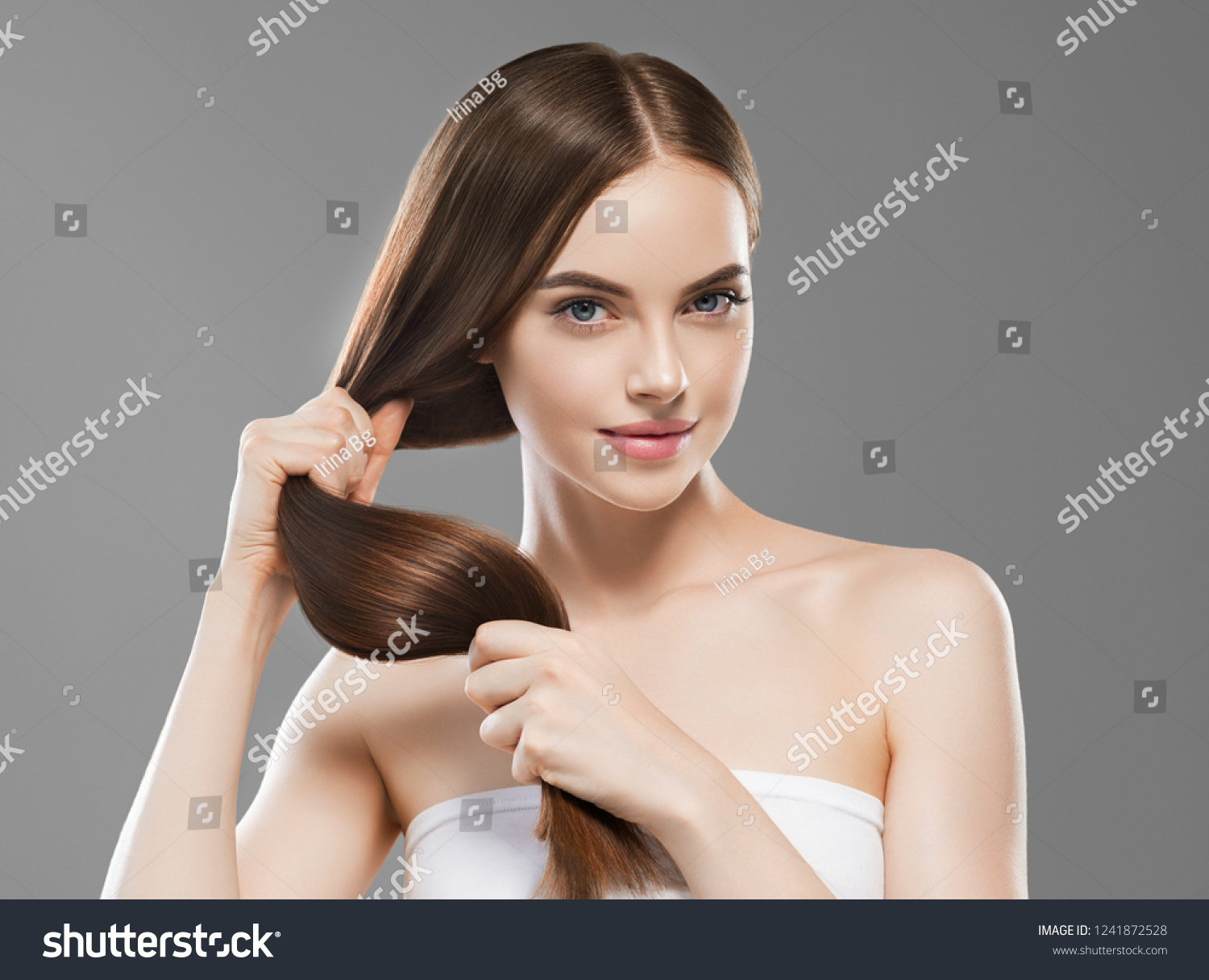 Smooth long brunette hair woman healthy and strong with healthy clean skin  female over gray background #1241872528